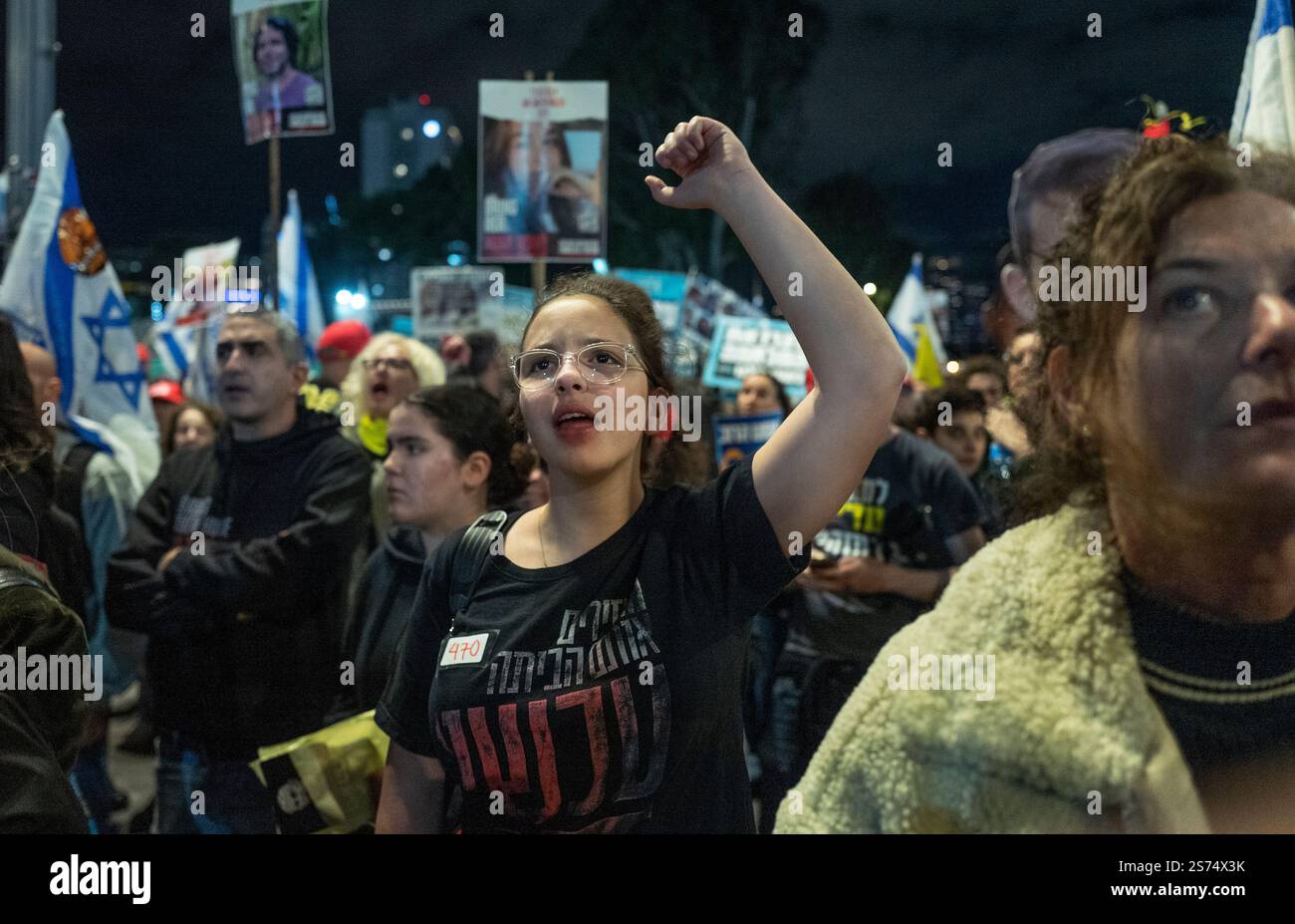 Tel Aviv, Israele. 18 gennaio 2025. Una donna israeliana che ha sollevato per prima e lei e altri urla "ora” mentre i nomi dei 98 ostaggi israeliani vengono letti durante una protesta di massa da migliaia di israeliani che chiedono la fine della guerra e di portare a casa i 98 ostaggi tenuti a Tel Aviv il 18 gennaio 2025 il giorno prima del cessate il fuoco con Hamas, che dovrebbe iniziare domani alle 8. Indossa un cartello con il numero 470 che indica il numero di giorni in cui gli ostaggi sono stati tenuti nella Striscia di Gaza da Hamas, dal loro attacco del 7 ottobre 2023. Foto di Jim Hollander/UPI credito: UPI/Alamy Live News Foto Stock