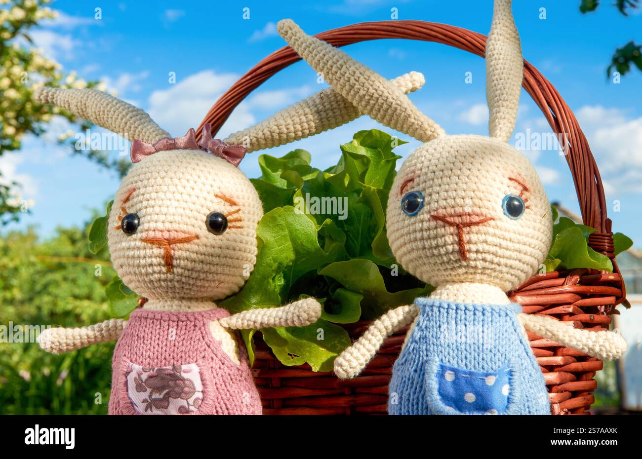 Coniglietti giocattolo nel cestino con fiori Foto Stock