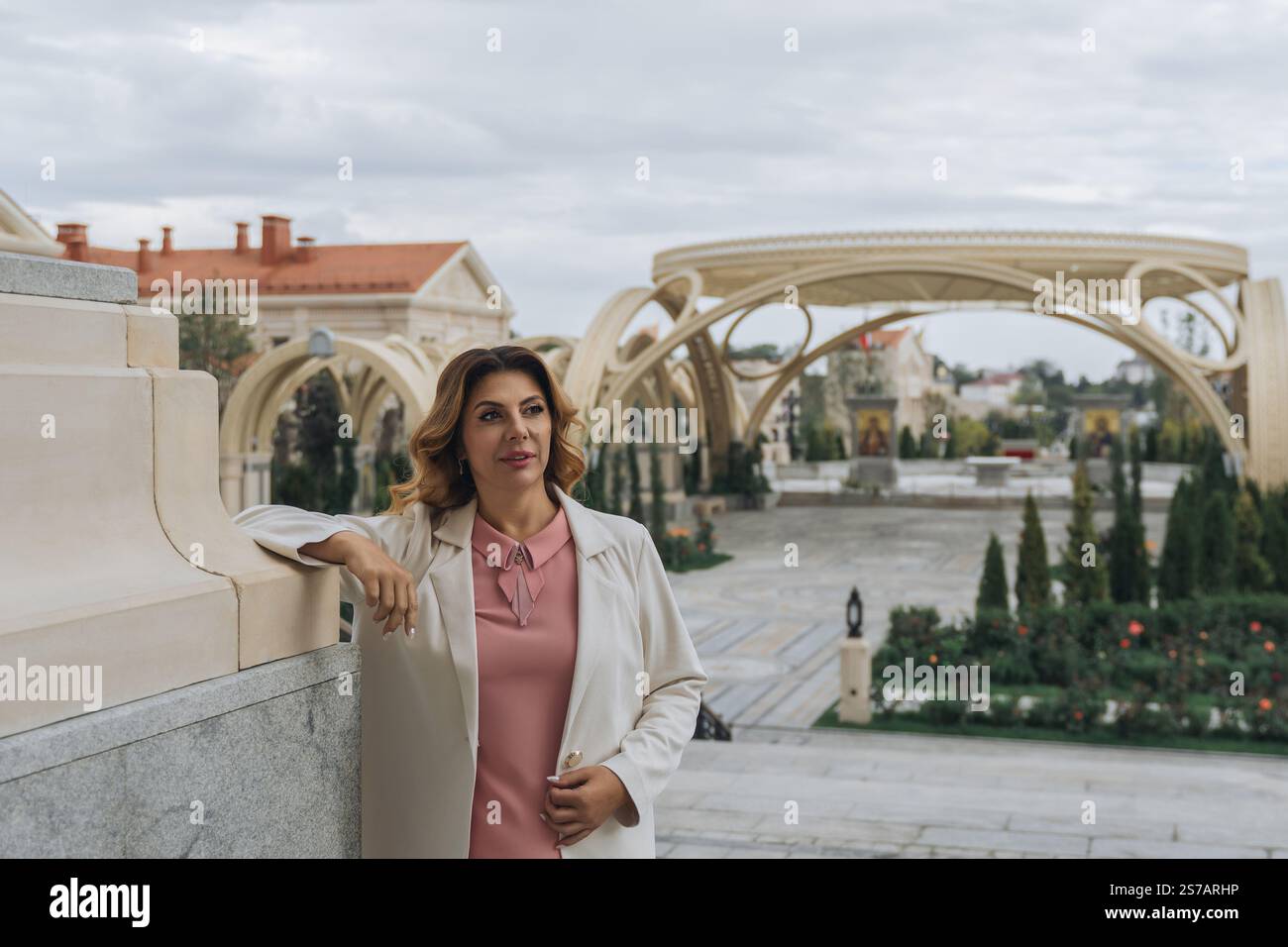 Donna, Parco, architettura: Una donna si trova in un parco con caratteristiche architettoniche uniche. Foto Stock