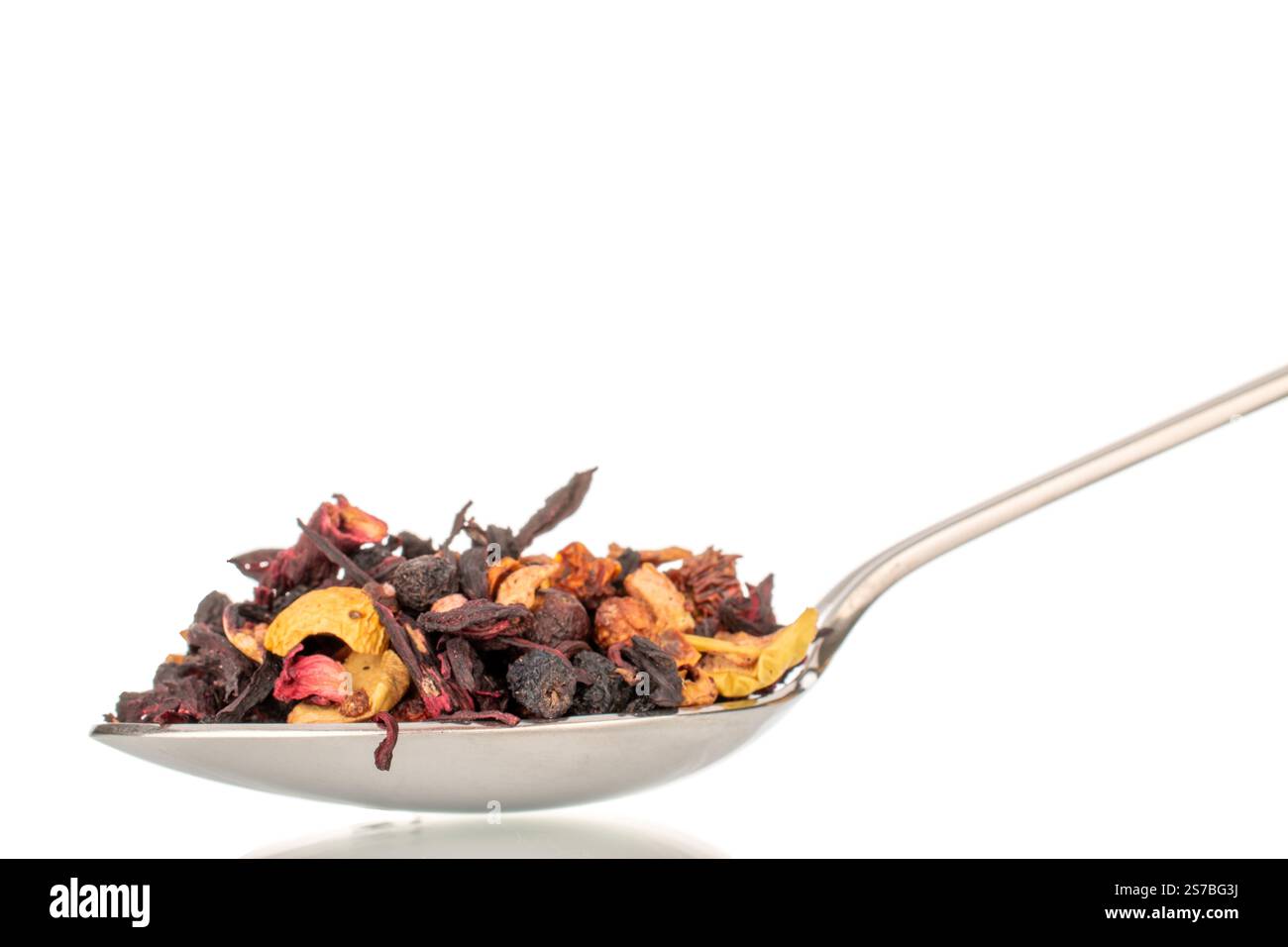 Tè aromatico della foresta dei Carpazi con cucchiaio di metallo, macro, isolato su sfondo bianco. Foto Stock