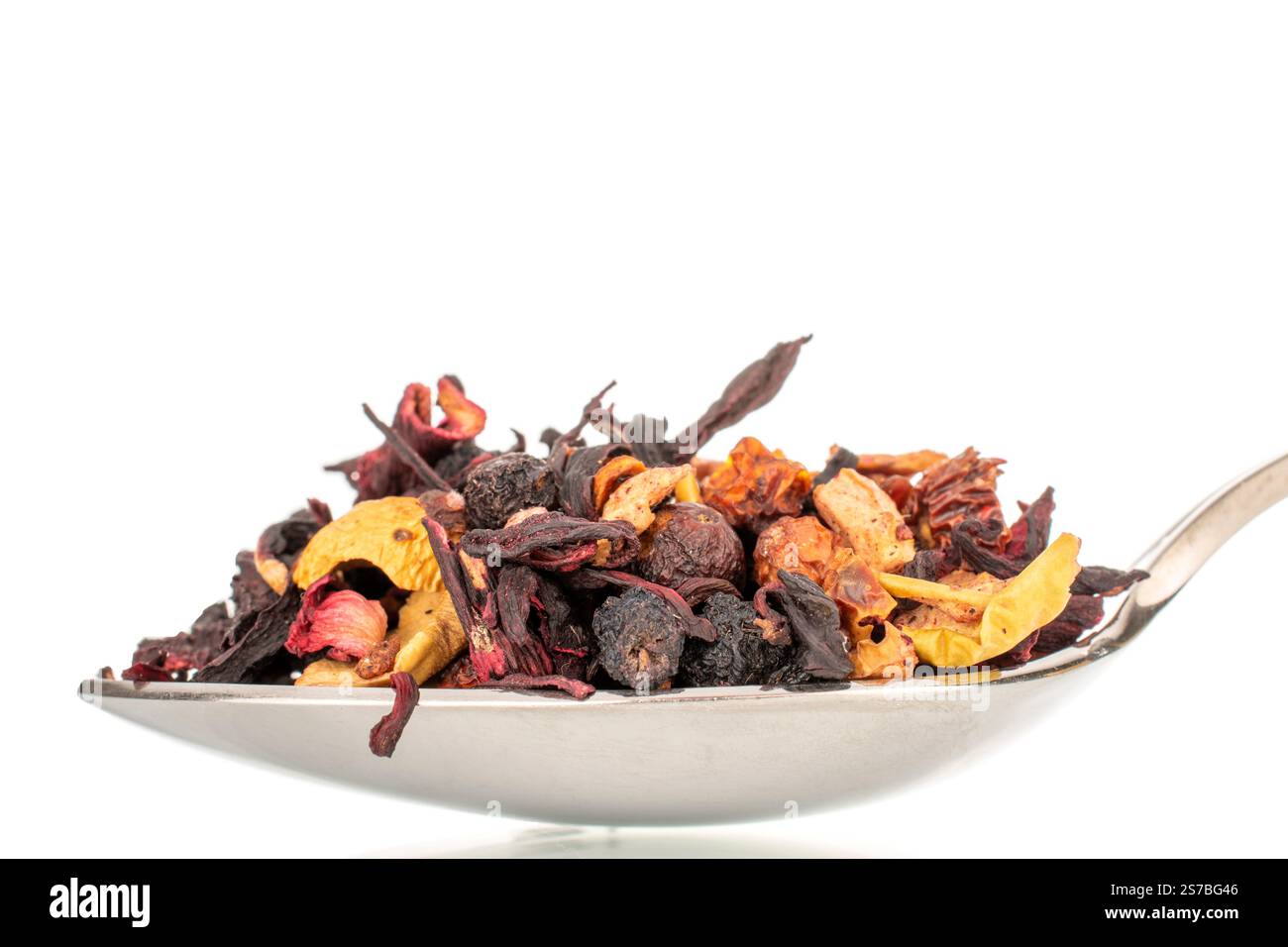 Tè aromatico della foresta dei Carpazi con cucchiaio di metallo, macro, isolato su sfondo bianco. Foto Stock