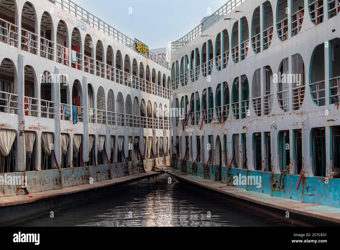 Passeggeri e rematori sulle barche a remi presso il vivace terminal di lancio di Sadarghat a Dacca, Bangladesh Foto Stock