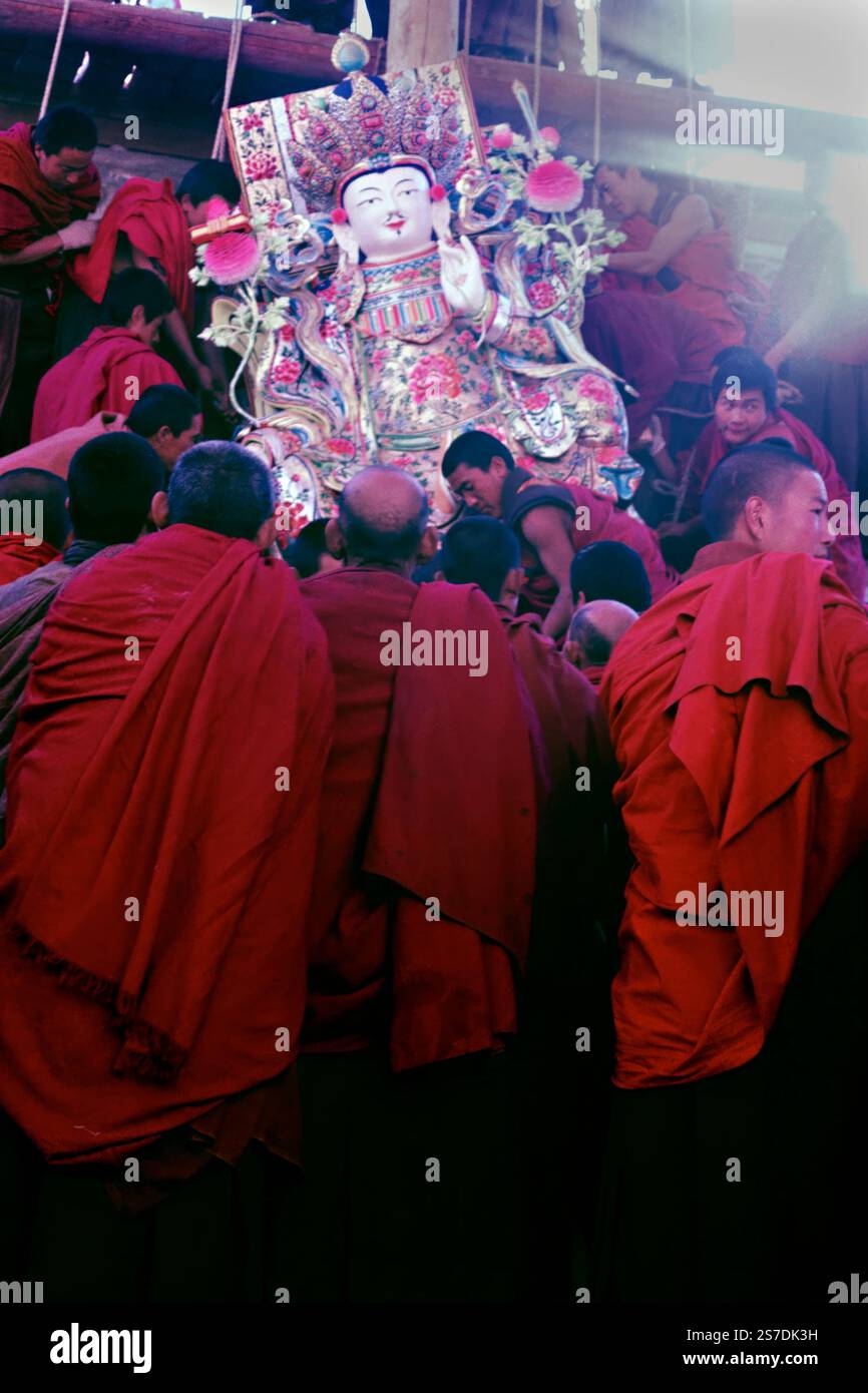 I monaci buddisti tibetani trasportano una massiccia scultura religiosa nelle prime ore del mattino durante il Festival della scultura del burro di Yak presso il monastero di Kumbum, noto anche come Monastero di Ta'er, 12 febbraio 1990 a Lusar, Xining, Qinghai, Cina. Le sculture sono assemblate in un massiccio tableau e esposte nel corso dell'anno successivo. Foto Stock
