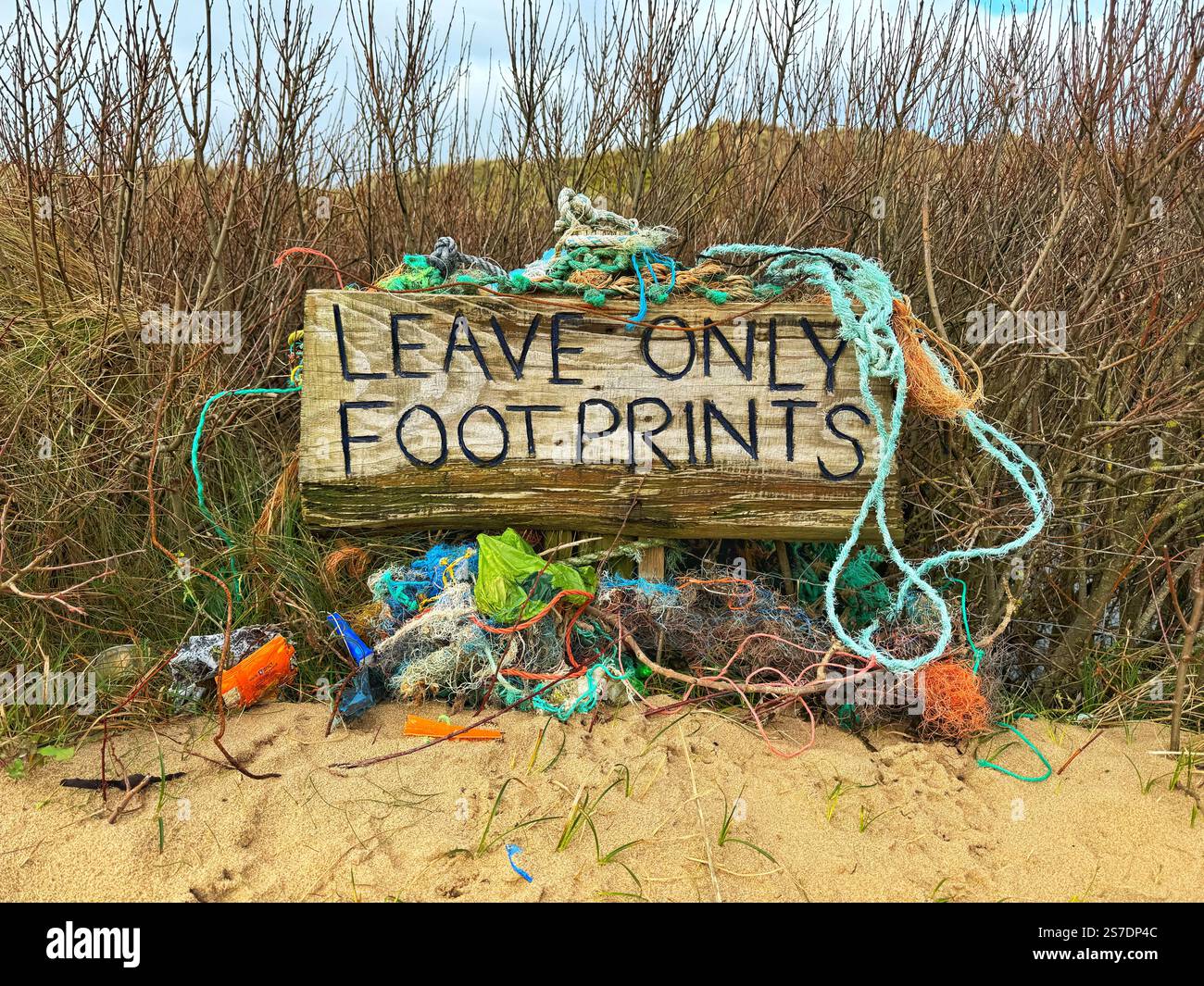 Leave Only Footprints sign with collected plastic waste in Sand Dune by Llangennith Beach, Gower, Wales, UK - Immagine stock catturata con smartphone