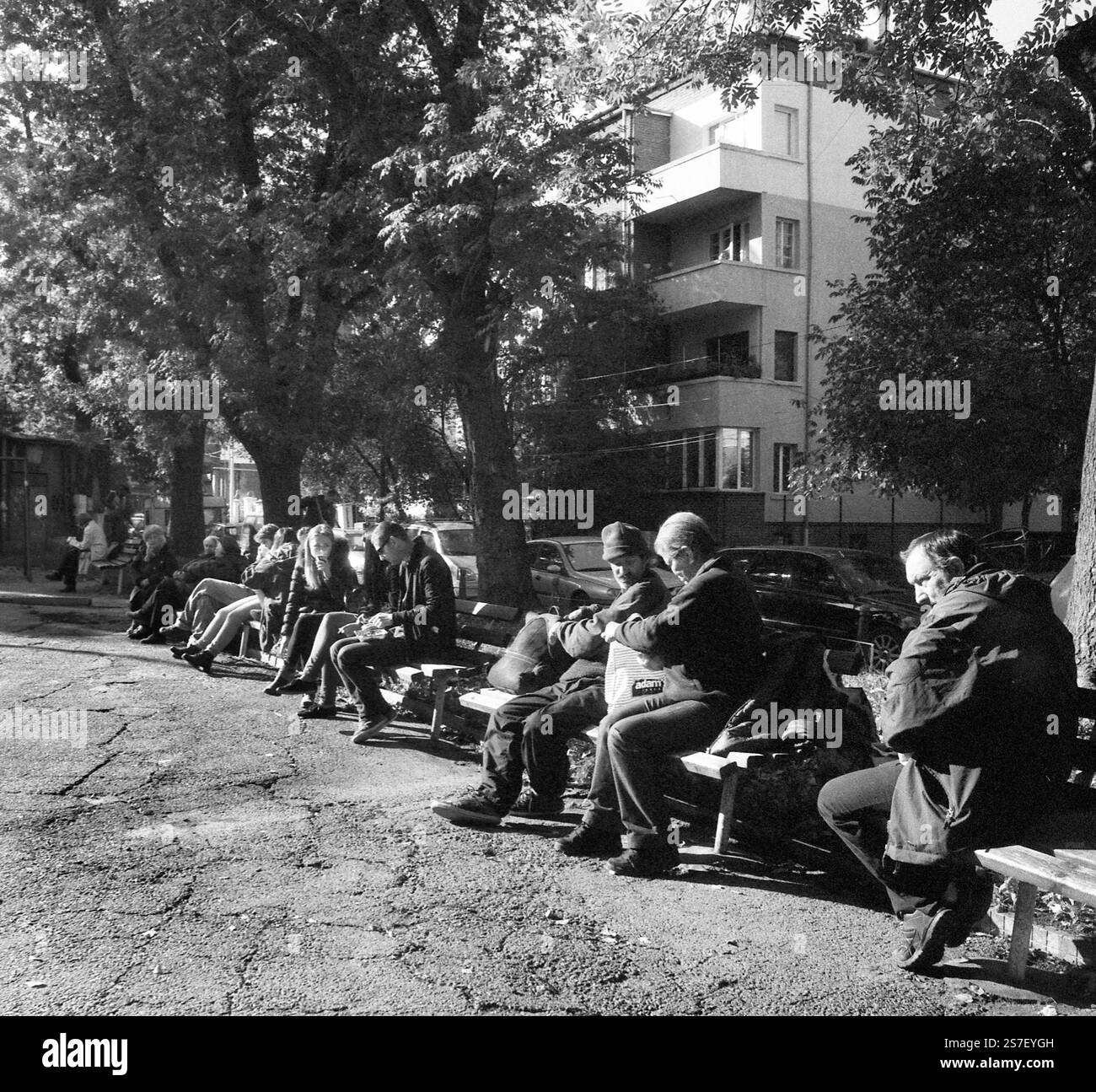 Persone sedute su panchine in un giardino in un giorno di ottobre soleggiato, Sofia, Bulgaria Foto Stock