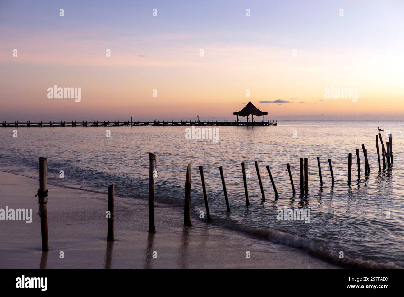 Messico, Puerto Morelos, molo con palapa all'alba su una spiaggia tranquilla. Foto Stock