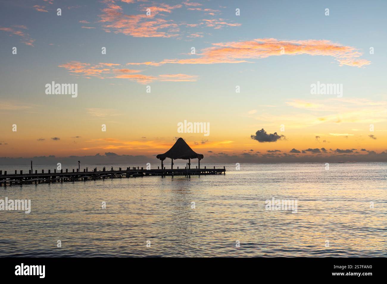 Messico, Puerto Morelos, molo con palapa all'alba su una spiaggia tranquilla. Foto Stock