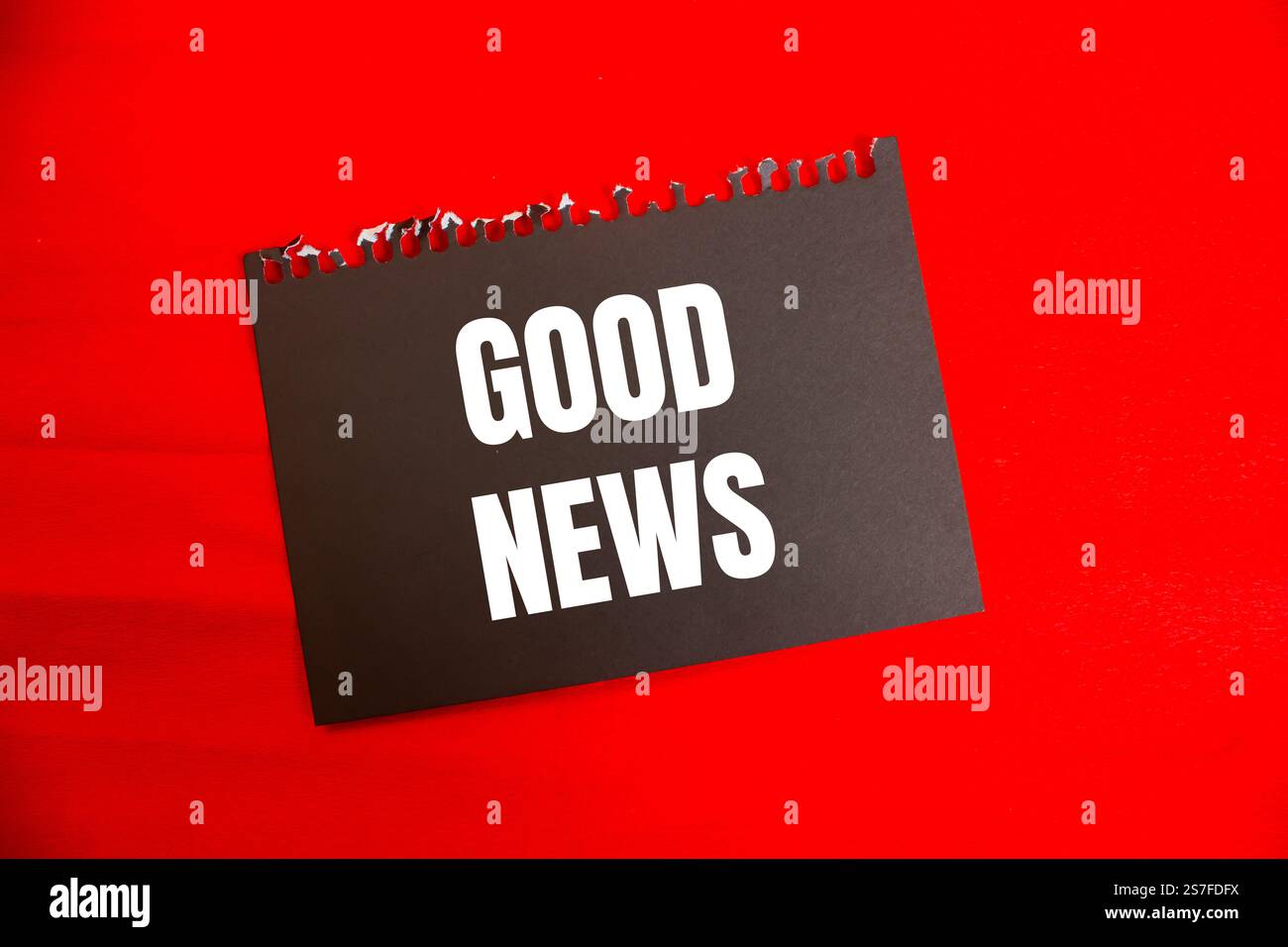 Messaggio di buone notizie scritto su carta nera con sfondo rosso. Simbolo di buone notizie concettuali. Copia spazio. Foto Stock