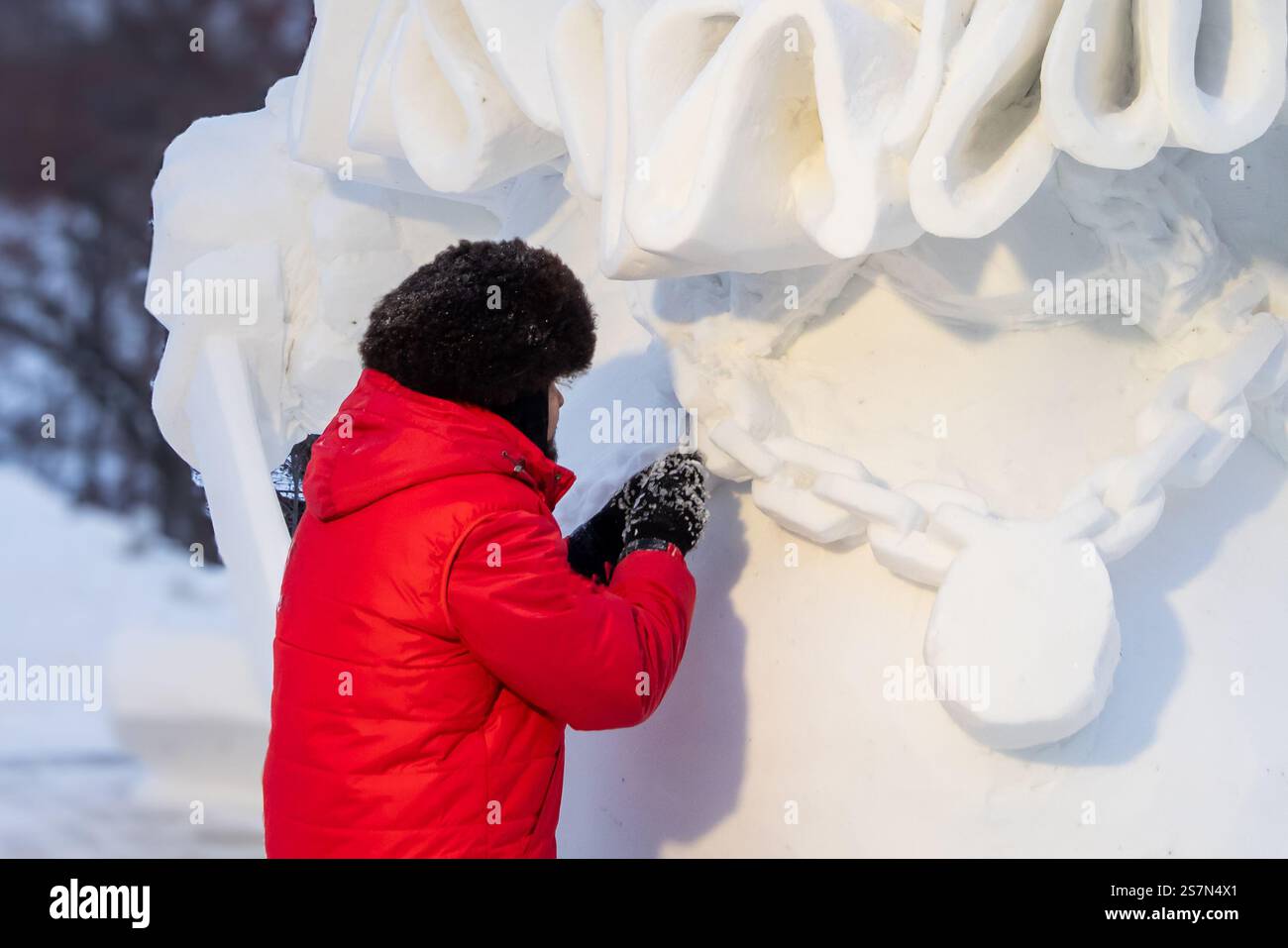 L'autore è uno scultore che crea elementi di una scultura di maneggio nella mattina d'inverno per strada. Professioni creative e creazione d'arte - urban li Foto Stock