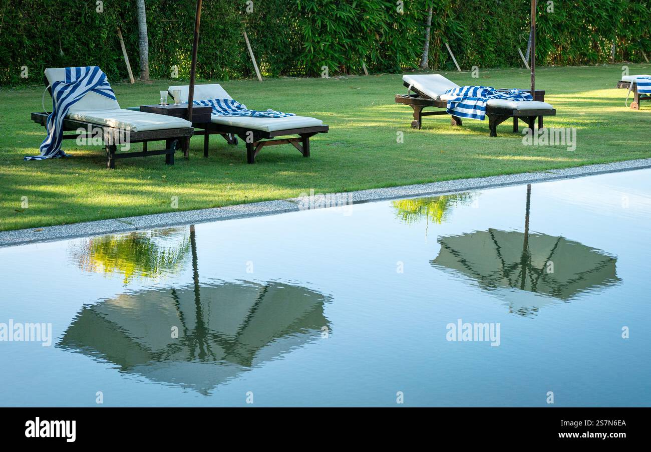 Piscina vuota con riflesso di ombrellone. Concetto di vacanza e vacanza. Foto Stock