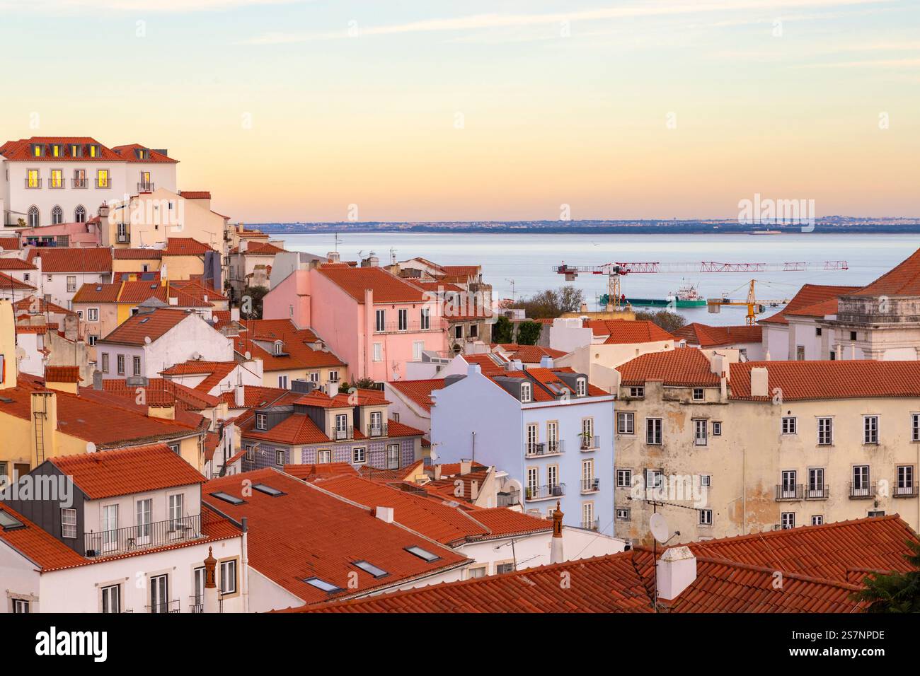 Tramonto su Alfama da Miradouro das portas do sol punto panoramico che mostra case tradizionali con tetti rossi nel quartiere più antico di Lisbona. Foto Stock