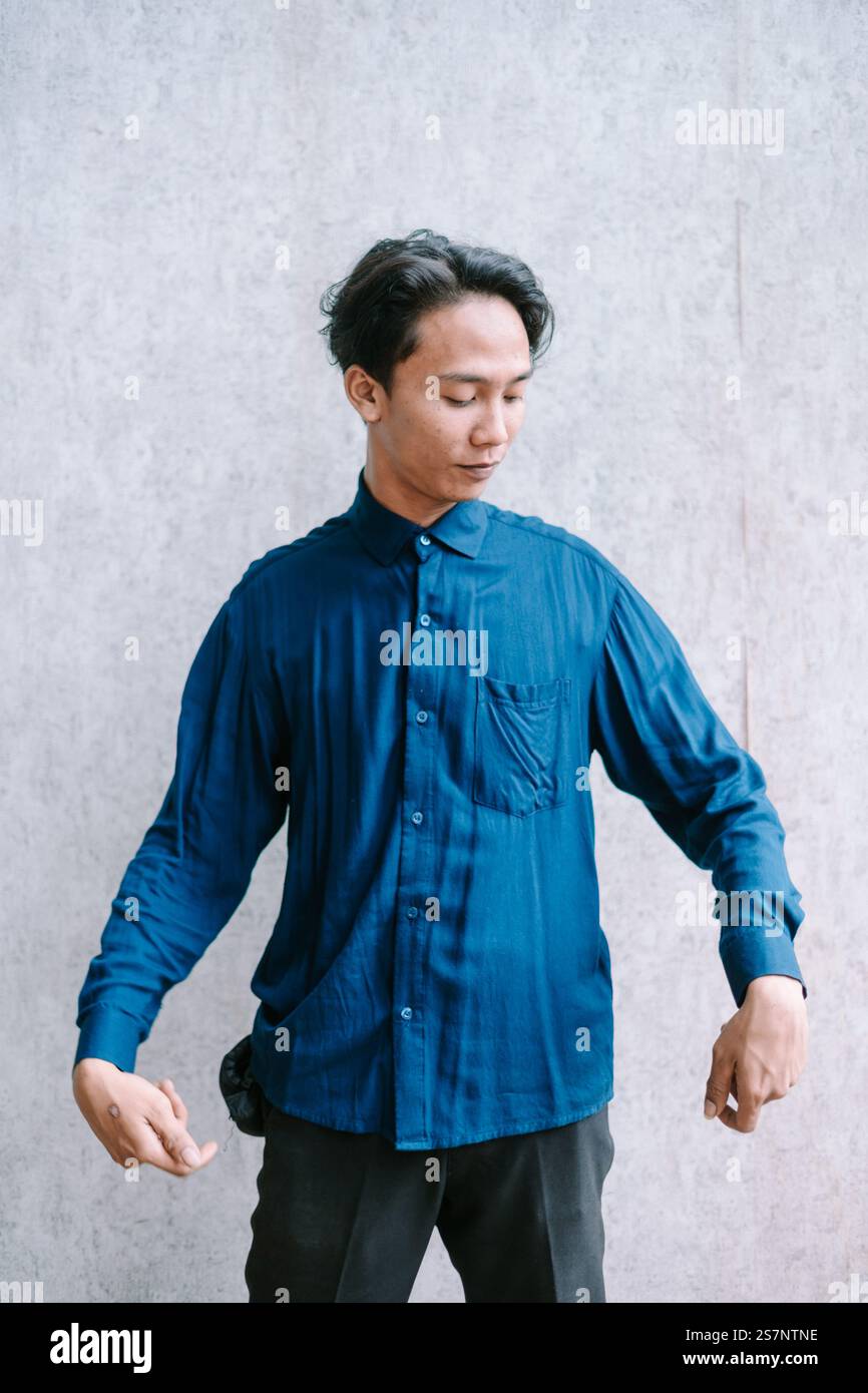 Giovane uomo che presenta la sua camicia blu, la moda e lo stile. Foto Stock
