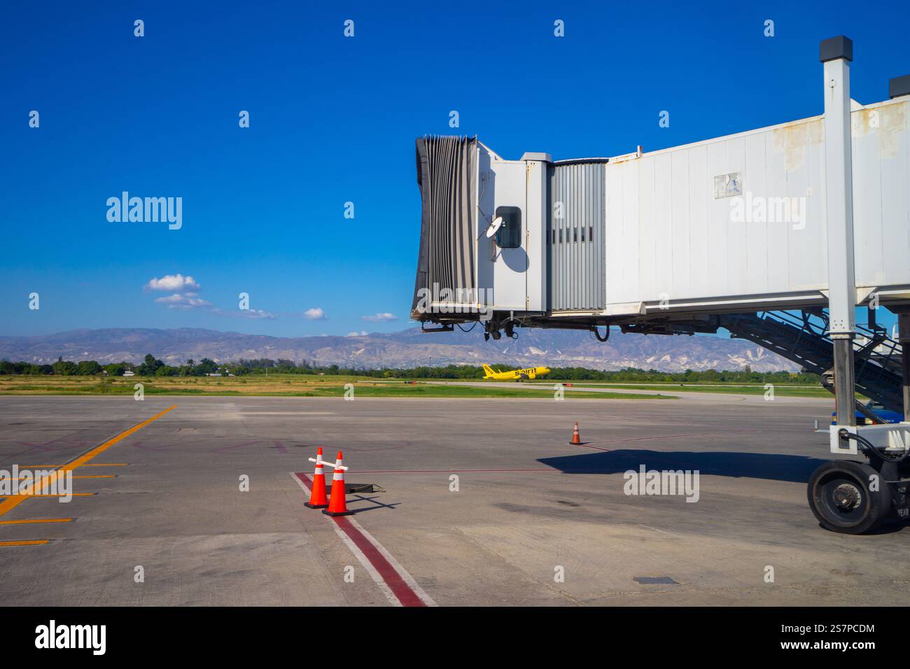 Aereo all'alba che prende il volo sullo sfondo, incorniciato da un'autostrada vuota in attesa dell'arrivo dell'aereo successivo all'aeroporto di Port-Au-Prince Foto Stock