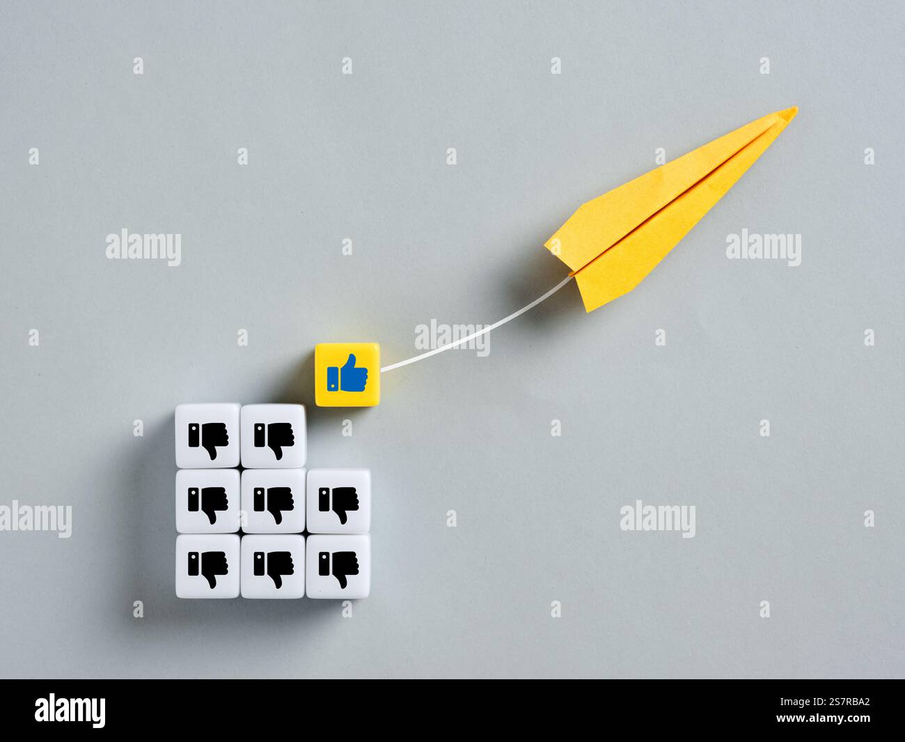 Il piano di carta giallo allontana un'icona simile da un gruppo di icone non simili, che rappresentano opinioni che cambiano Foto Stock