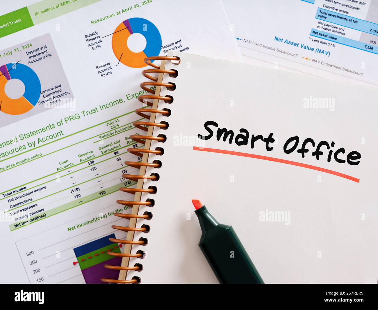 Notebook che mette in risalto i concetti di ufficio intelligente con un brillante marcatore arancione, circondato da report finanziari e grafici, che rappresentano lo spazio di lavoro moderno ef Foto Stock