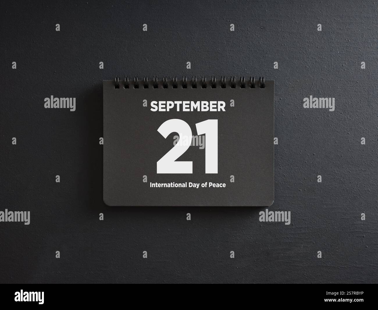 Pagina di calendario nera che mostra il 21 settembre, giornata internazionale della pace, che riposa su sfondo scuro Foto Stock