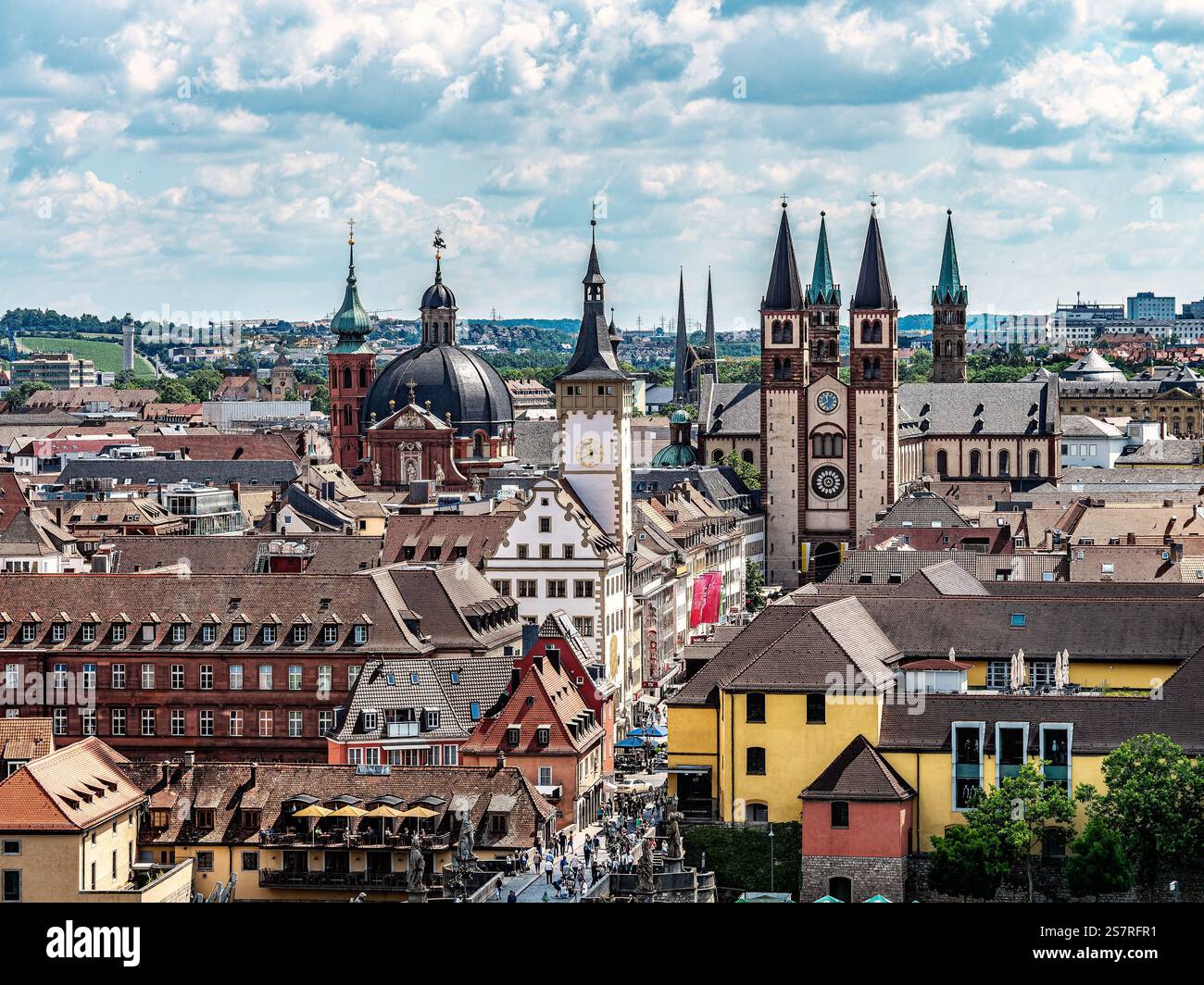 Vista panoramica di una storica città europea caratterizzata da un'architettura tradizionale, un fiume e un ponte sotto un cielo azzurro limpido con nuvole sparse, sho Foto Stock