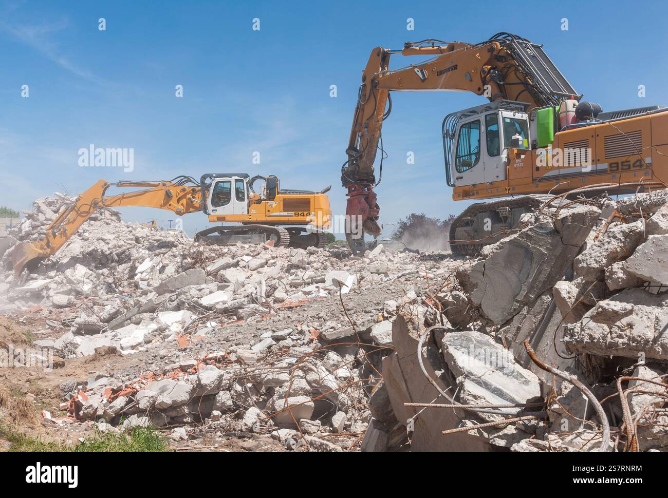 Cantiere di decostruzione. Pile di rifiuti di cemento armato. 2 escavatori LIEBHERR 954 dotati di frantumatore e 944 dotati di benna. Foto Stock