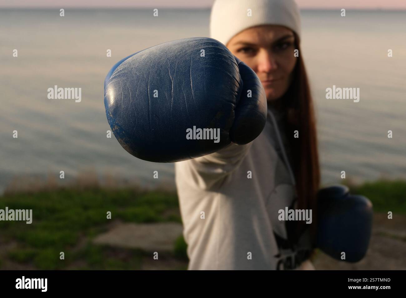 Primo piano di un guanto da boxe sulla mano di una donna Foto Stock