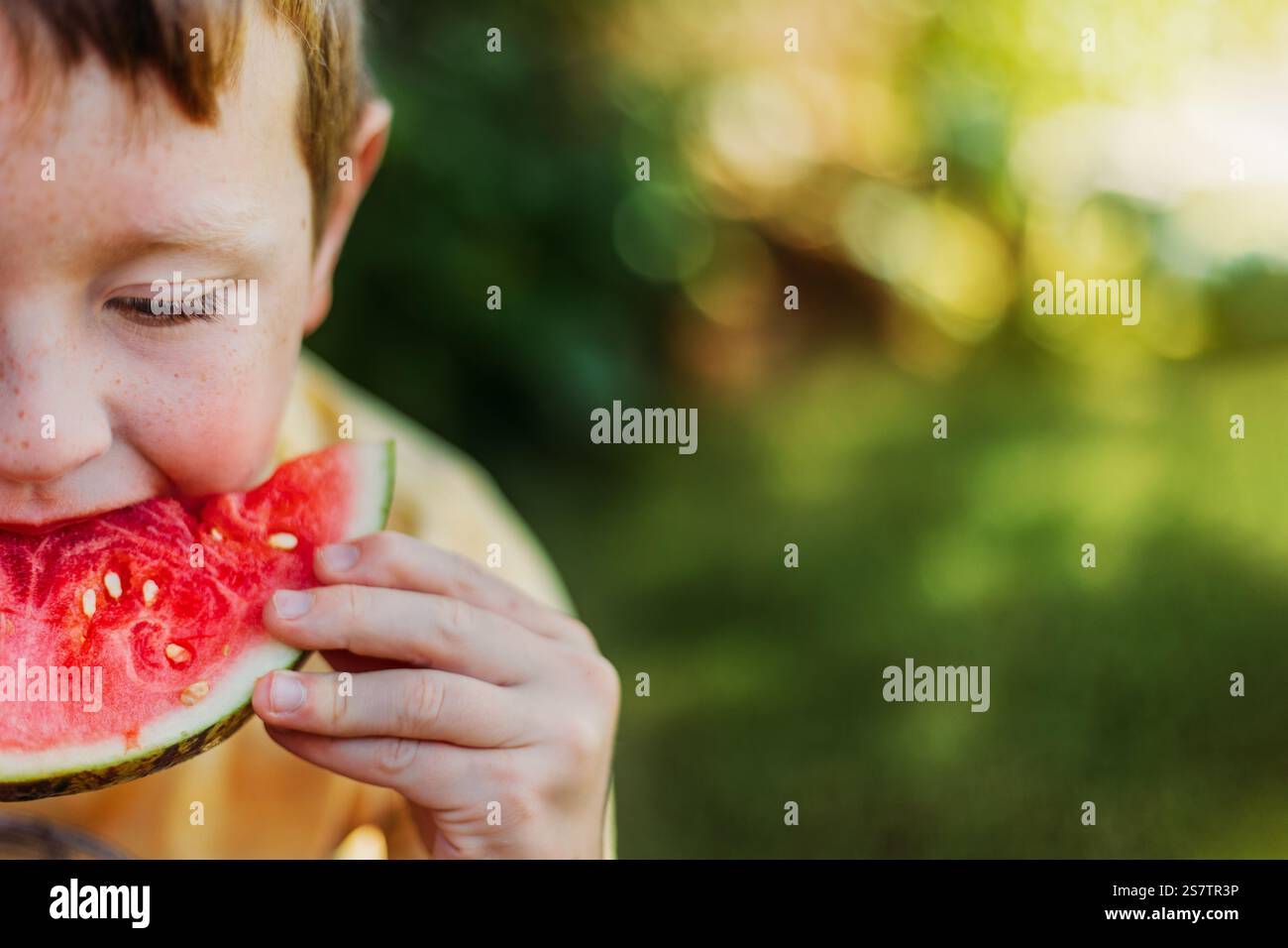 Ragazzo che mangia un anguria il giorno dell'estate Foto Stock