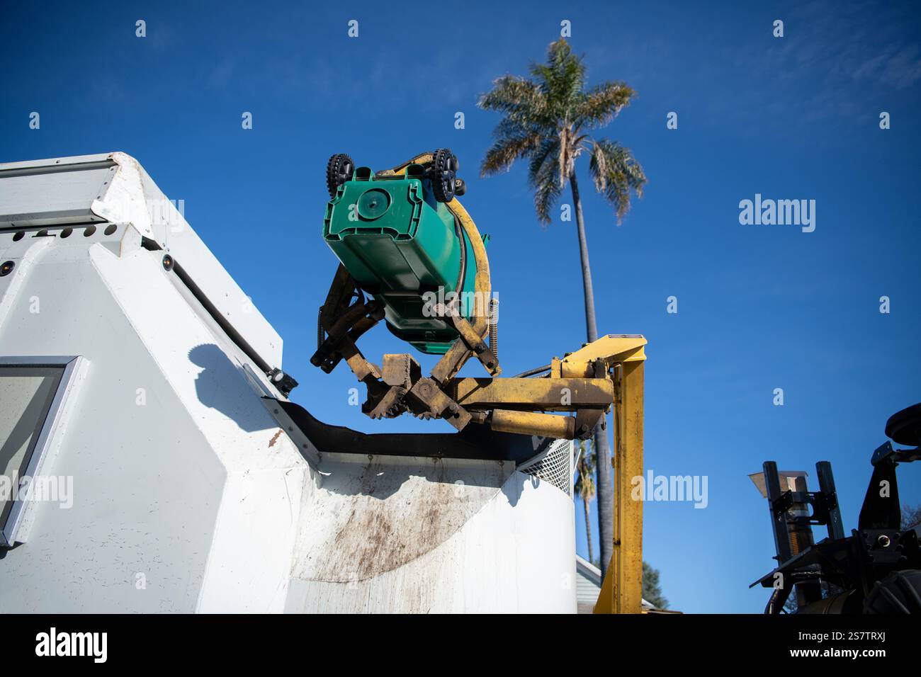 Il contenitore verde residenziale viene sollevato per scaricare i rifiuti organici Foto Stock