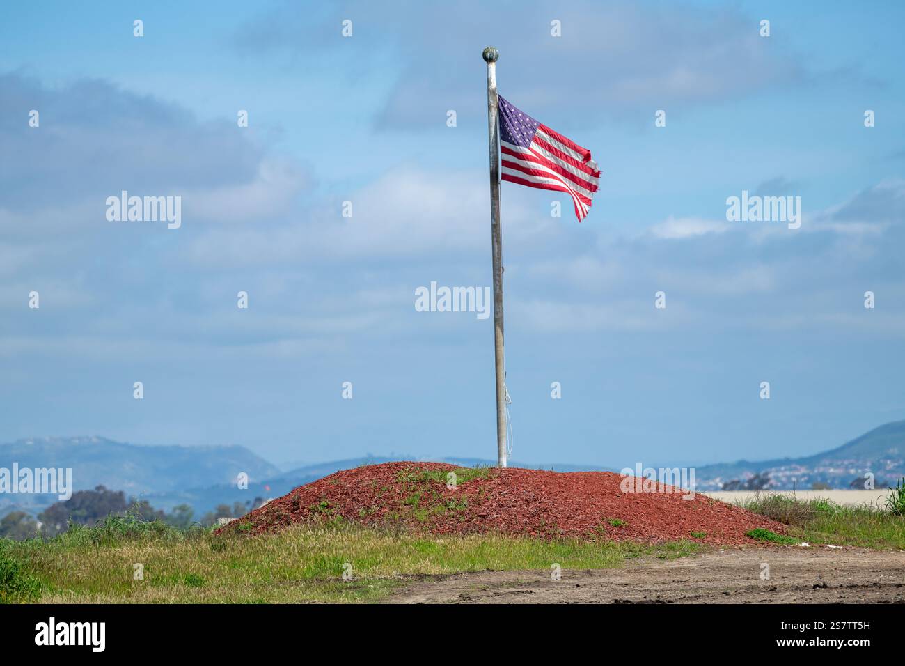 La bandiera americana a pezzi vola su una piccola collina di trucioli di legno rosso Foto Stock