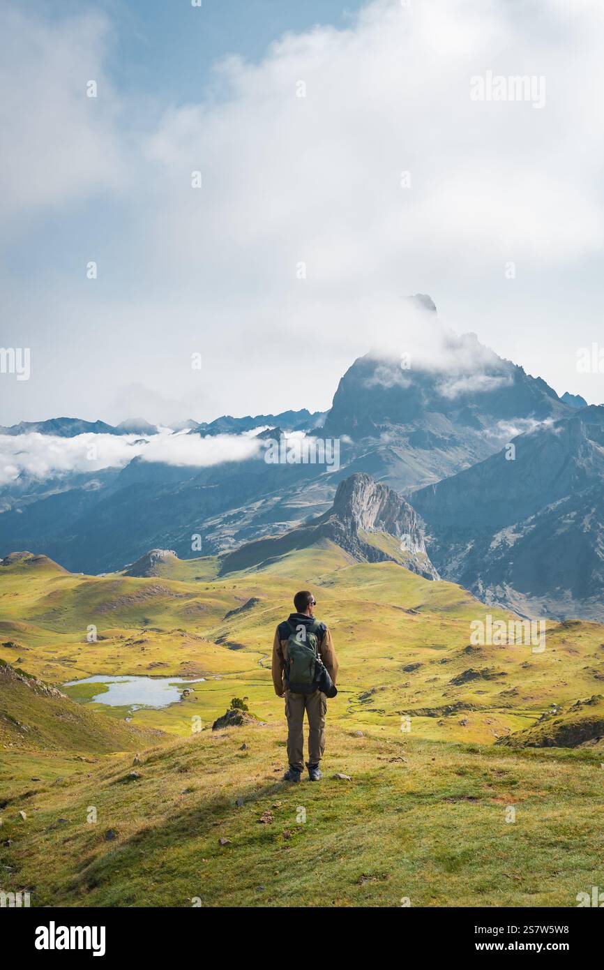 Una persona in piedi su un maestoso paesaggio montuoso con una vista panoramica e mozzafiato Foto Stock