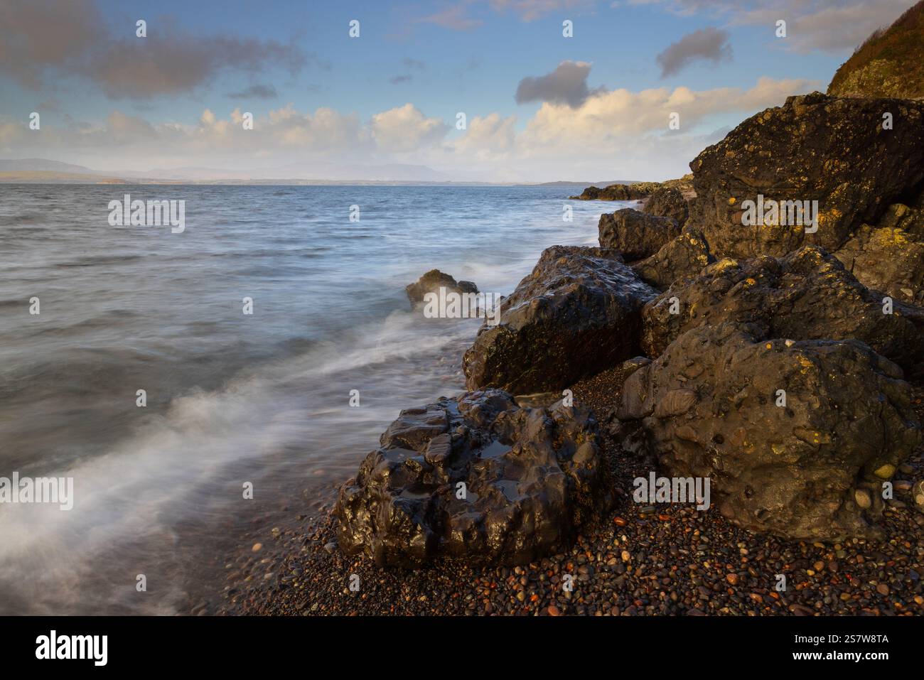 Onde che si infrangono su una spiaggia di ghiaia a Ganavan, vicino Oban, West Highland, Scozia, Regno Unito. Foto Stock