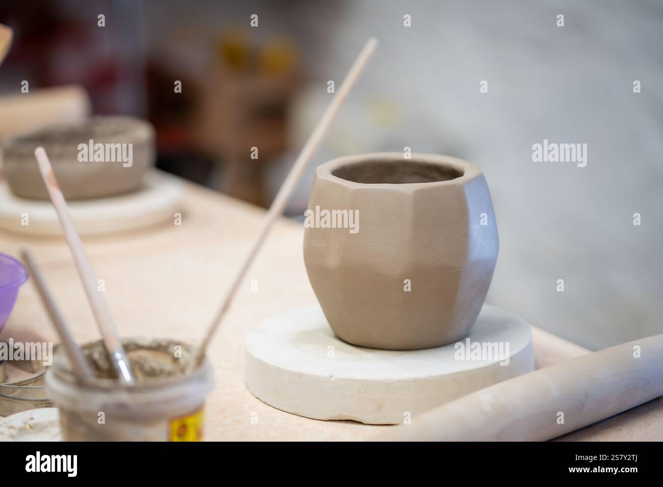 Creazione di vasi sfaccettati. Ceramica di argilla fatta a mano che si asciuga prima di essere fuoco. Tavolo nello studio di ceramica. Laboratorio di ceramica. Il processo di creazione della ceramica. Foto Stock