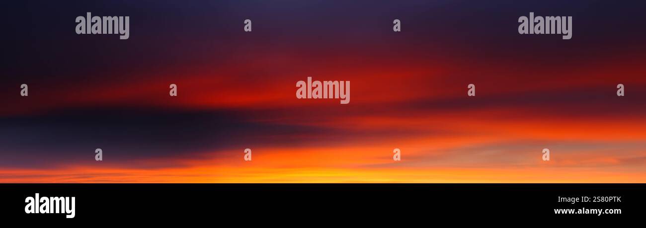 Bagliori nel cielo panoramico con nuvole lisce, con una bellezza surreale e quasi astratta in arancione e viola Foto Stock