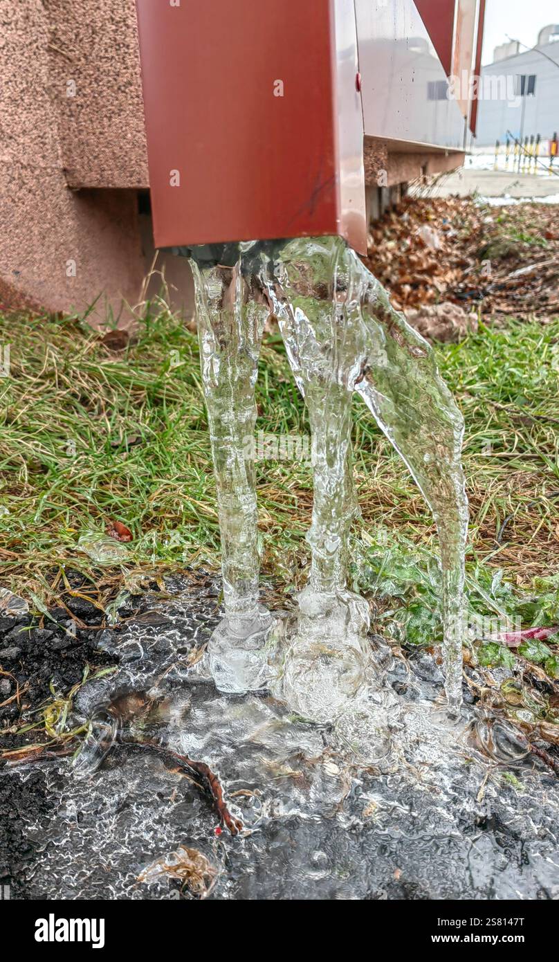 Icicles from the Red Tin Gutter: Nature's Winter ArtWork Foto Stock