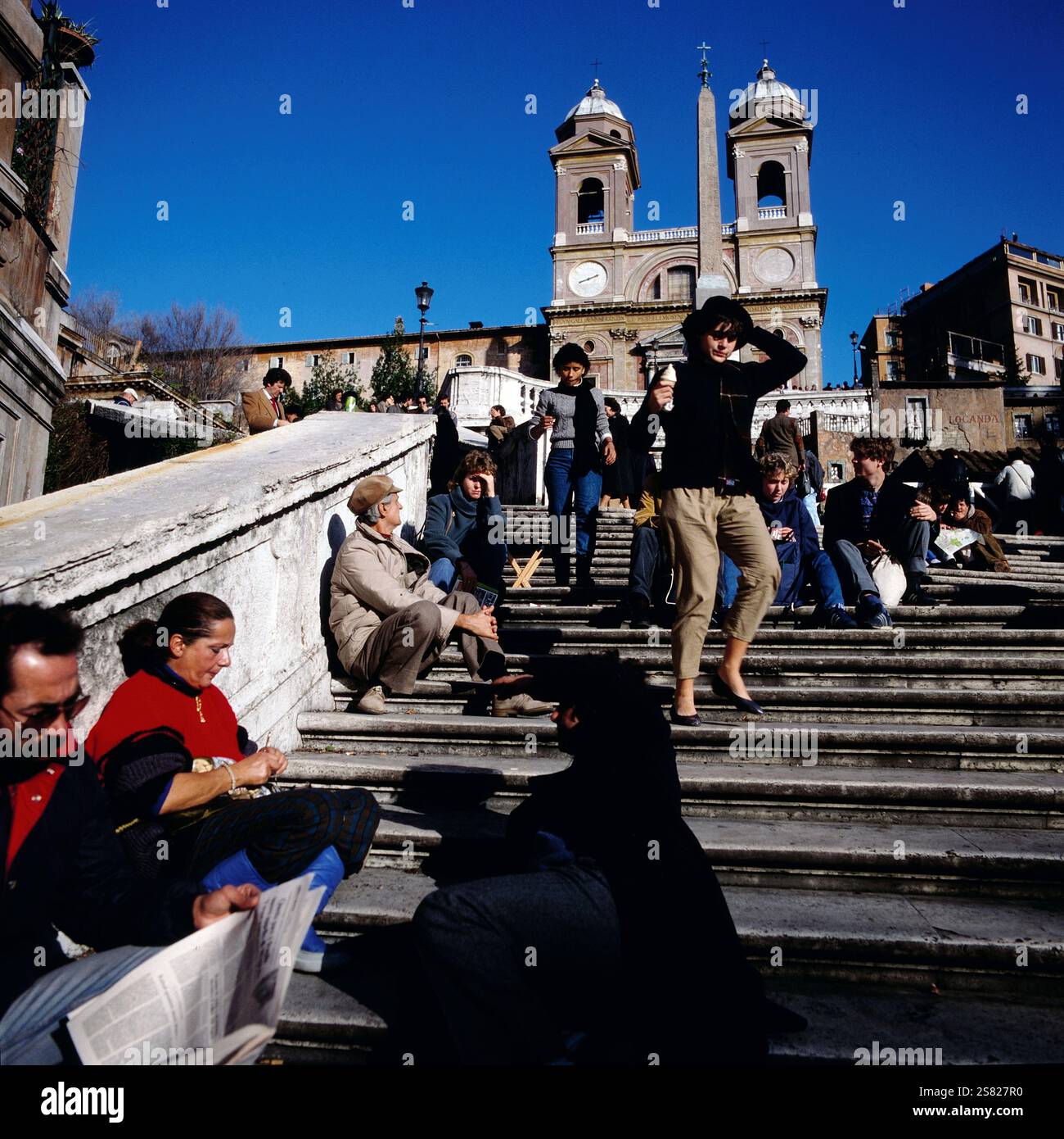 Touristen genießen einen sonnigen Tag auf der Spanischen Treppe in Rom mit der Kirche Trinita dei Monti im Hintergrund, Italien um 1977. Foto Stock