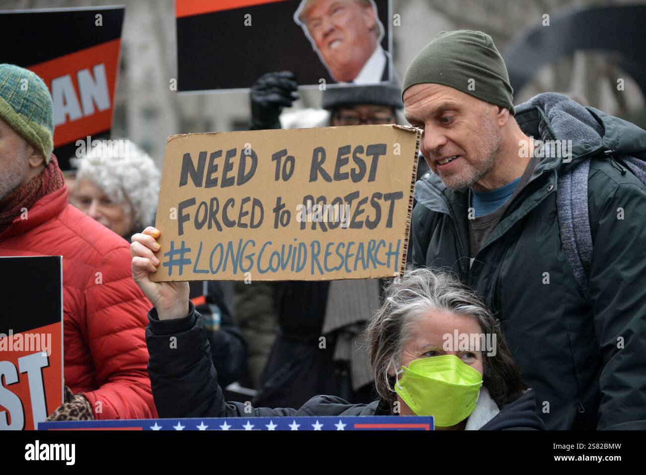 Persona su una sedia a rotelle con un cartello durante la marcia del popolo del 2025 contro l'imminente amministrazione Trump a New York. Foto Stock