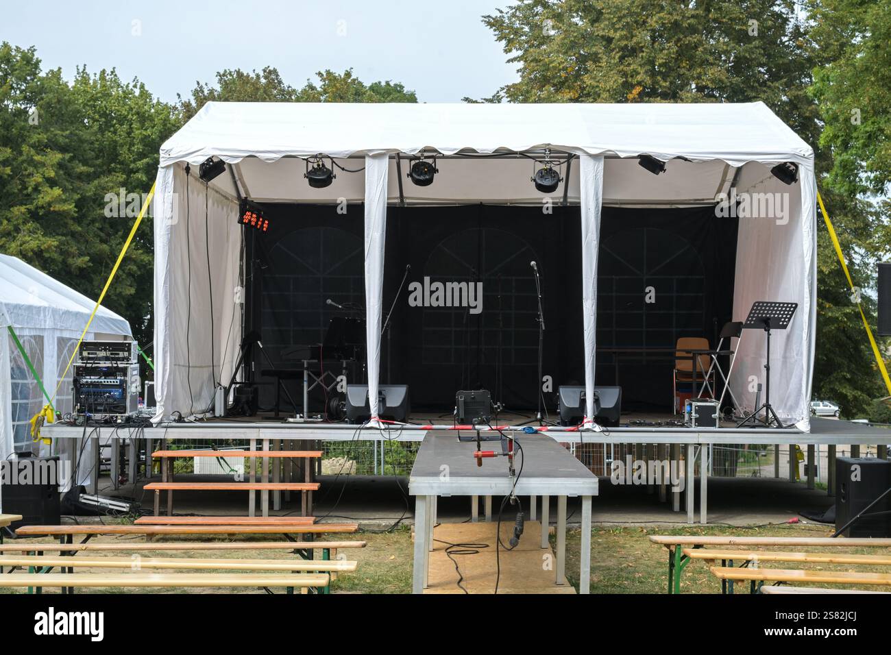 Palco all'aperto e panche in legno per il pubblico in costruzione per un festival musicale in campagna, focus selezionato Foto Stock Palco all'aperto e panche in legno per il pubblico in costruzione per un festival musicale in campagna, focus selezionato Foto Stock