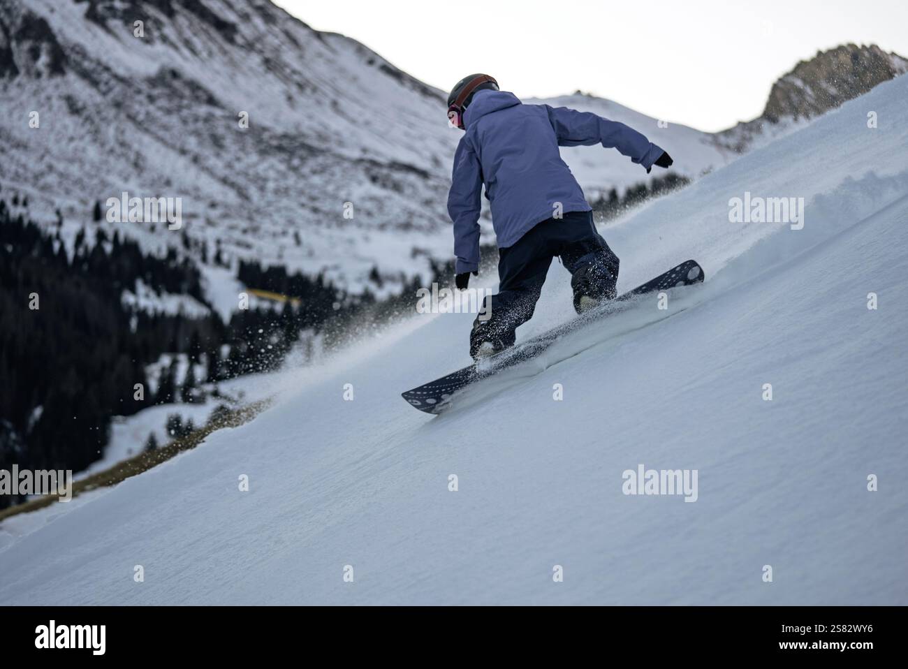 Gruppo di persone che fanno snowboard in montagna in una giornata invernale di sole. Lezioni di snowboard con istruttori locali. I bambini imparano a fare snowboard con un istruttore Foto Stock