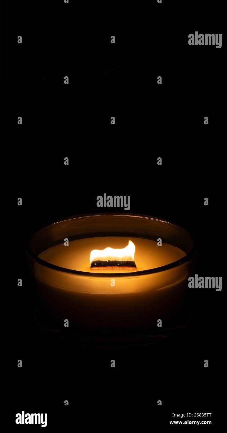 Si accende la candela al buio. Banner verticale con spazio per il testo. Sfondo per telefono. Foto Stock