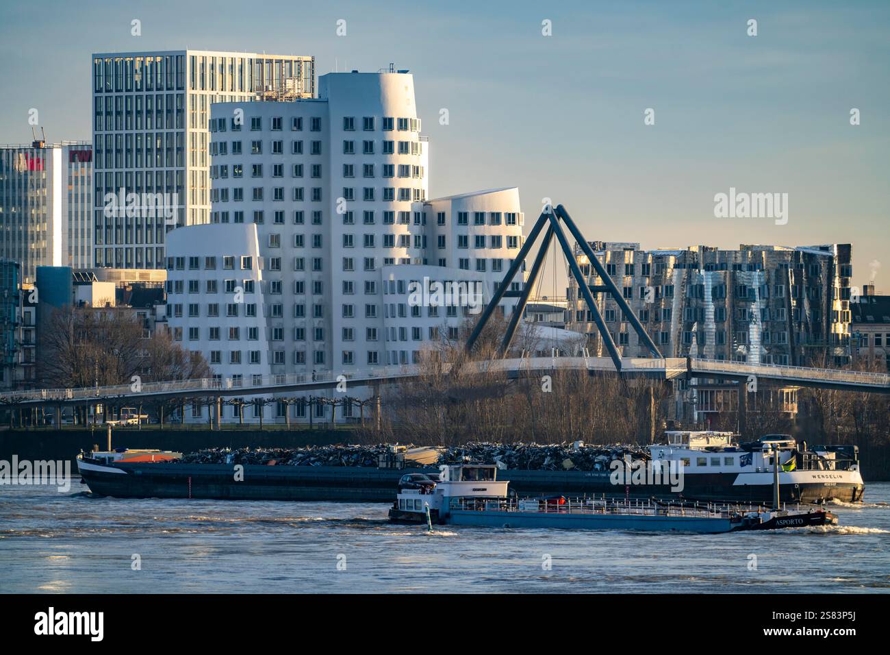 Edifici a Medienhafen di Düsseldorf, edifici Gehry, Neuer Zollhof e l'edificio per uffici RWI dietro di esso, nave cargo sul Reno, NRW, Germania Foto Stock