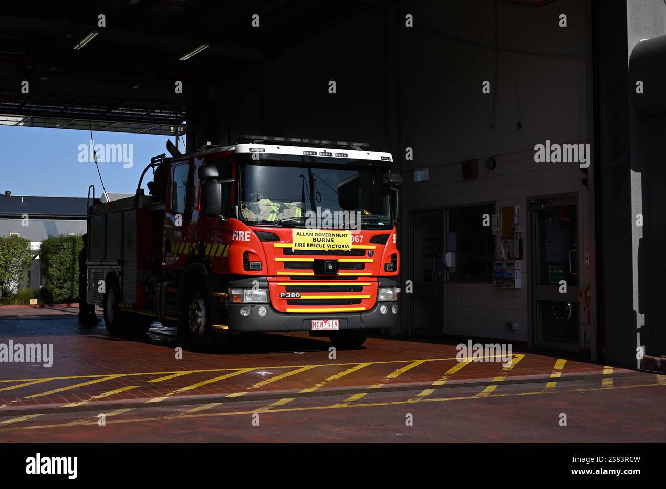 Camion dei vigili del fuoco Scania P 320 illuminato dal sole parcheggiato alla stazione FRV 32 con un messaggio governativo anti-lavoro che afferma: "Allan government Burns Fire Rescue Victoria" Foto Stock