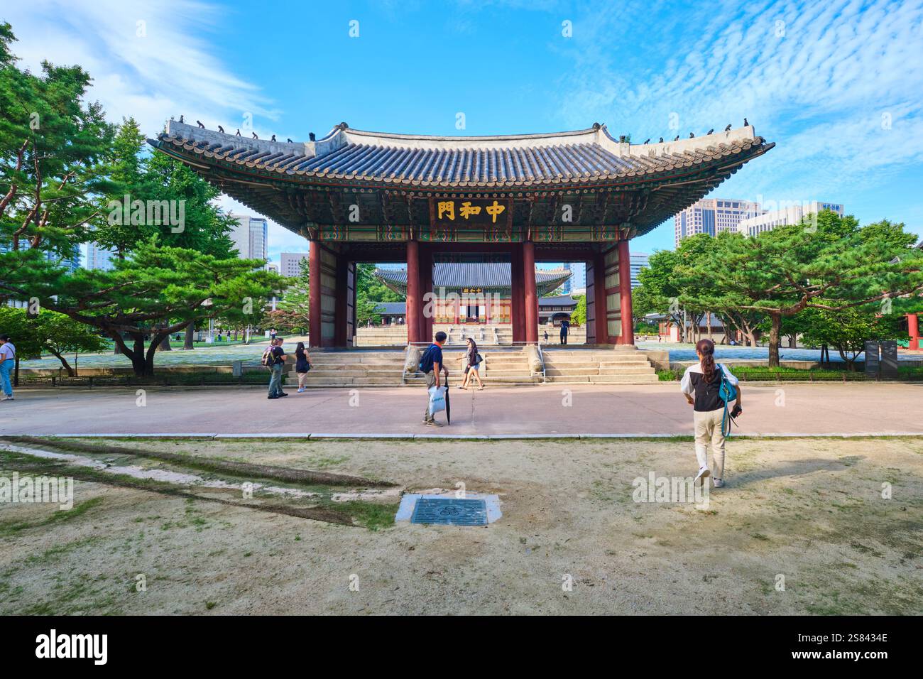 Persone che camminano attraverso il cancello di Junghwamun. Al Palazzo reale Deoksugung di Seoul, Corea del Sud. Foto Stock
