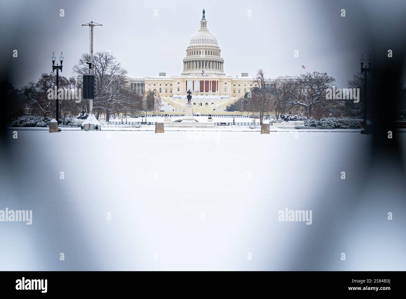 Washington, D.C. U.S.A. - 6 gennaio 2025: Veduta del Campidoglio nella neve attraverso la recinzione nera prima della distesa del presidente Carter. Foto Stock