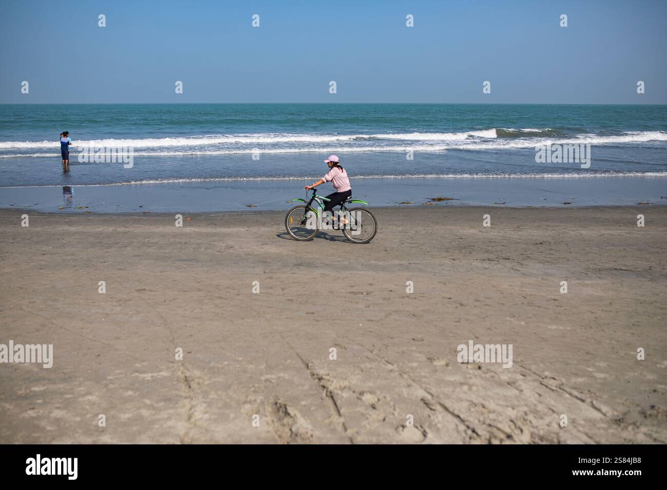 Un turista corre in bicicletta lungo la spiaggia di Saint Martin's Island, situata nella Baia del Bengala, Cox's Bazar, Bangladesh. Foto Stock