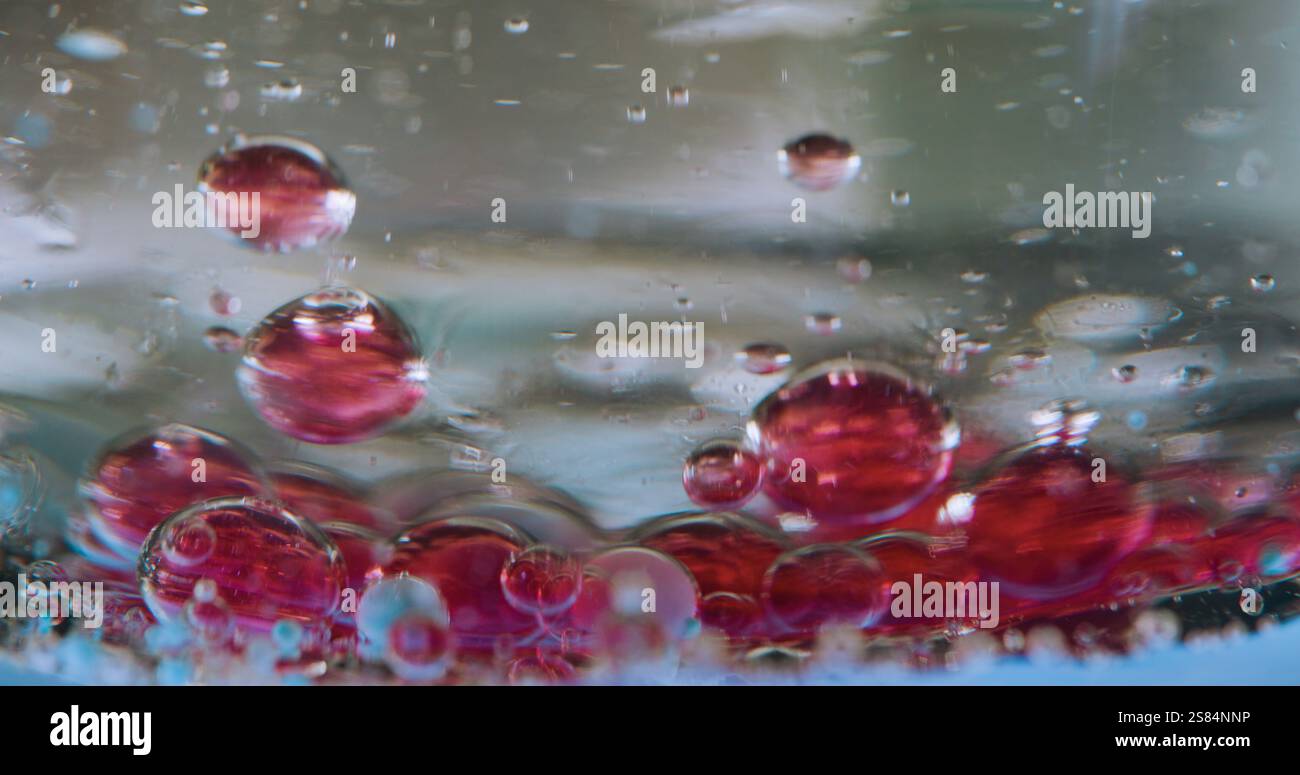 Bokeh emulsione bokeh. Lascia cadere il gel. Ingrediente rosso di sedimentazione sul fondo. Miscelazione del liquido d'aria a densità diversa. Gocciolatoio del lavello. Primo piano del processo chimico. Foto Stock