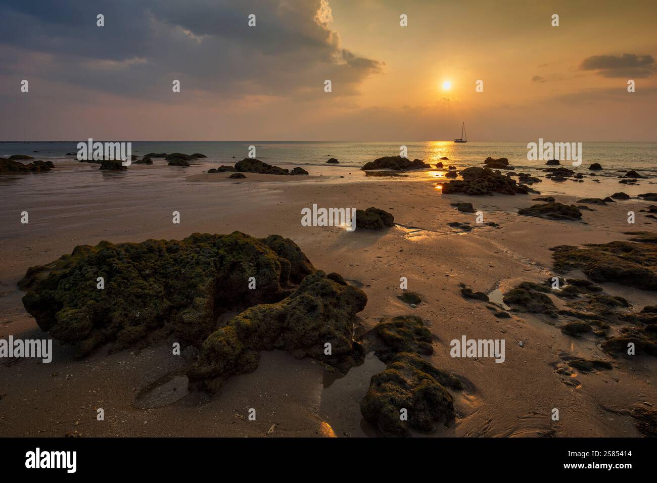Splendido paesaggio roccioso e vuoto di Long Beach (Phra Ae Beach), mare, sole e cielo nuvoloso al tramonto a Koh Lanta, Thailandia. Foto Stock