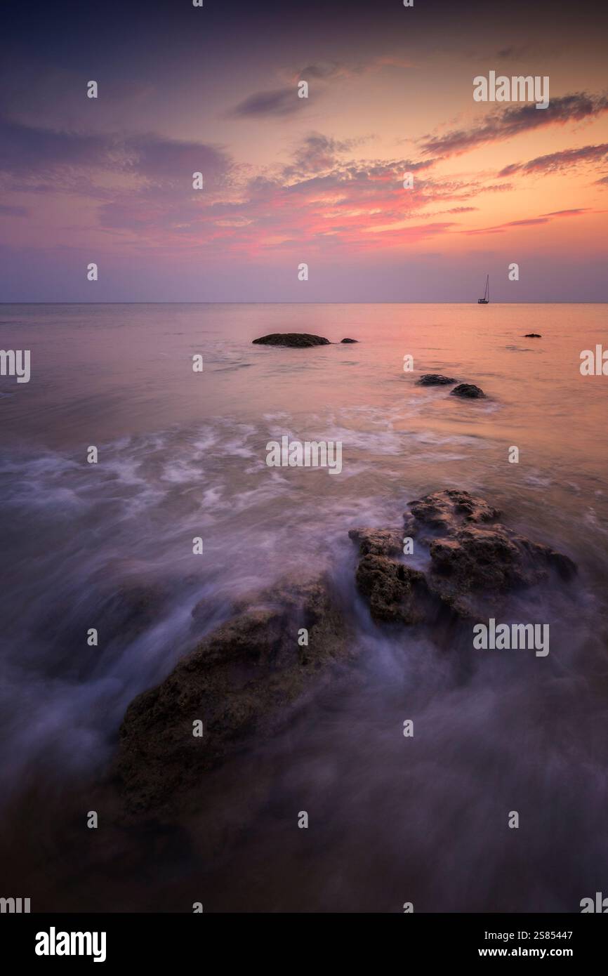 Splendido paesaggio di cielo colorato e rocce ondulate sulla Long Beach (Phra Ae Beach) a Koh Lanta, Thailandia, al tramonto. Foto Stock