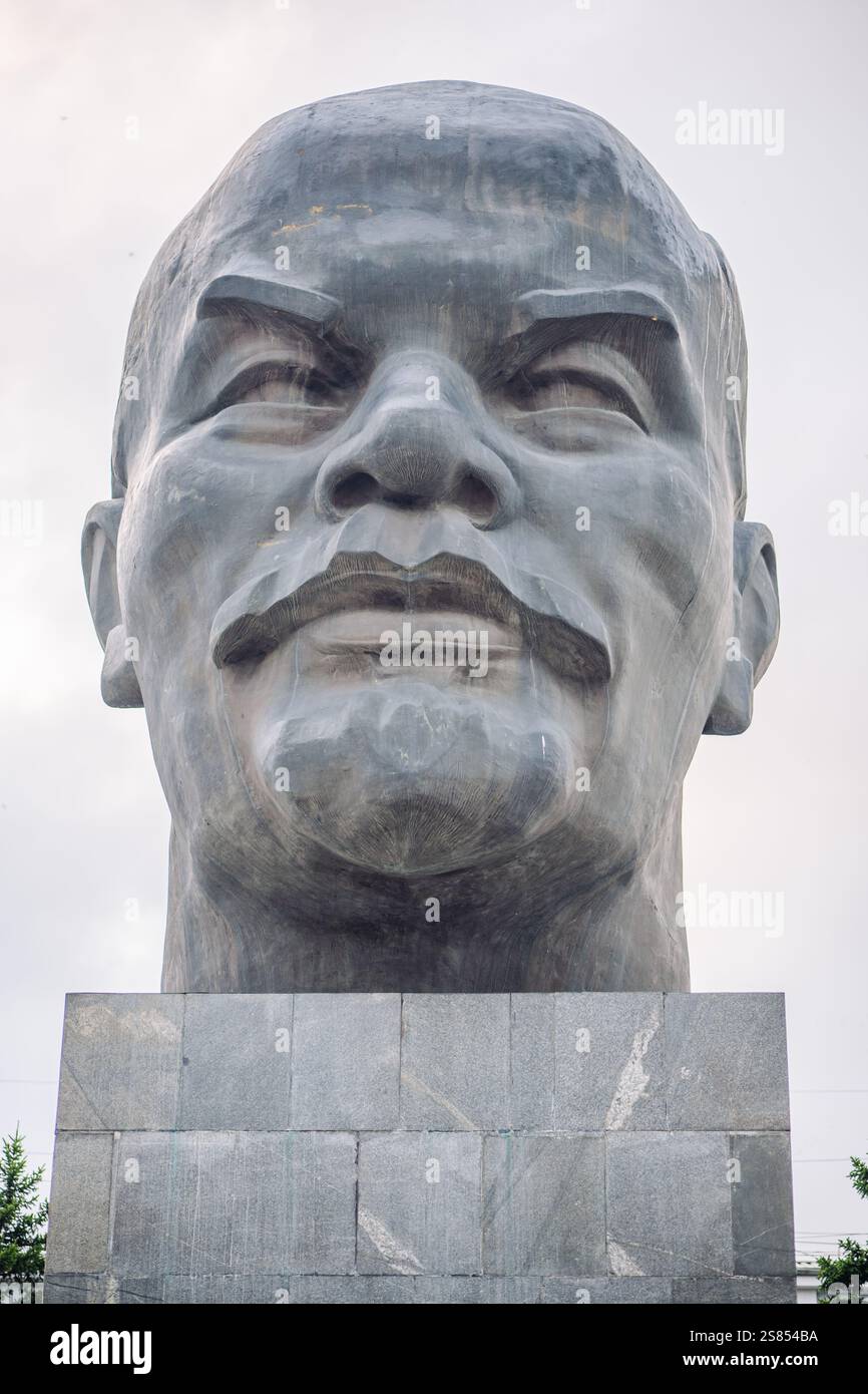 Monumentale testa in pietra di vladimir lenin, fondatore dell'unione sovietica, che si erge alto contro un cielo nuvoloso Foto Stock