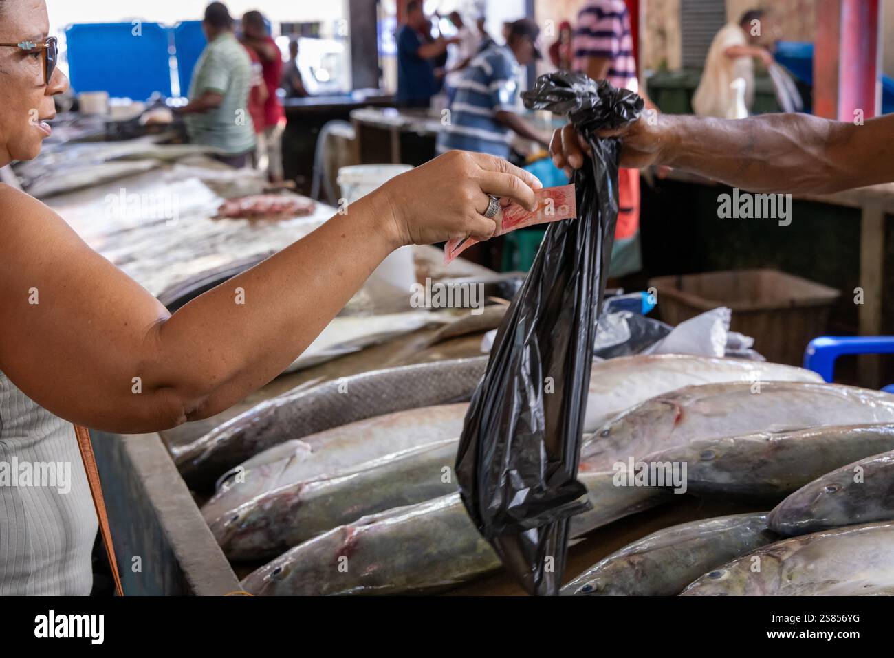 Donna che acquista pesce fresco al mercato del pesce di Victoria, Mahé, Seychelles Foto Stock