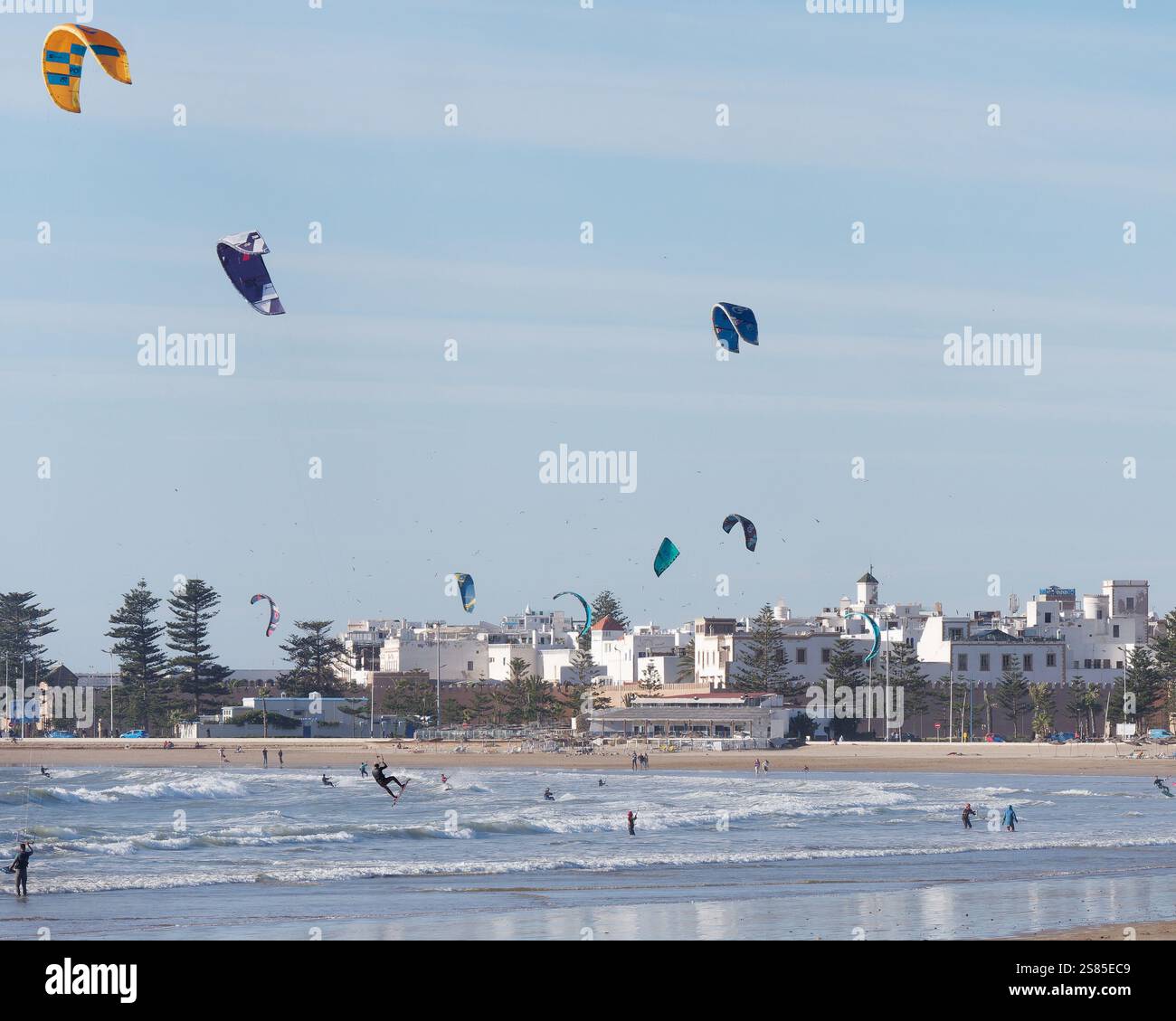 Kite Surfers in mare mentre si vola in aria con la storica Medina alle spalle nella città di Essaouira, in Marocco. 20 gennaio 2025 Foto Stock