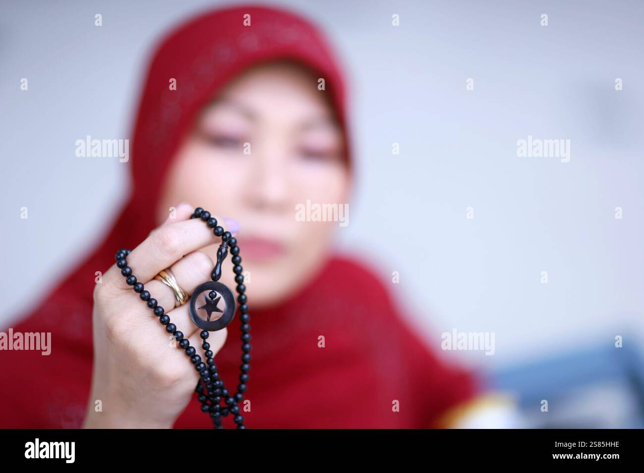 Donna musulmana che prega con perline islamiche in mano, meditazione religiosa, culto, concetto Ramadan, Surabaya, Indonesia Foto Stock