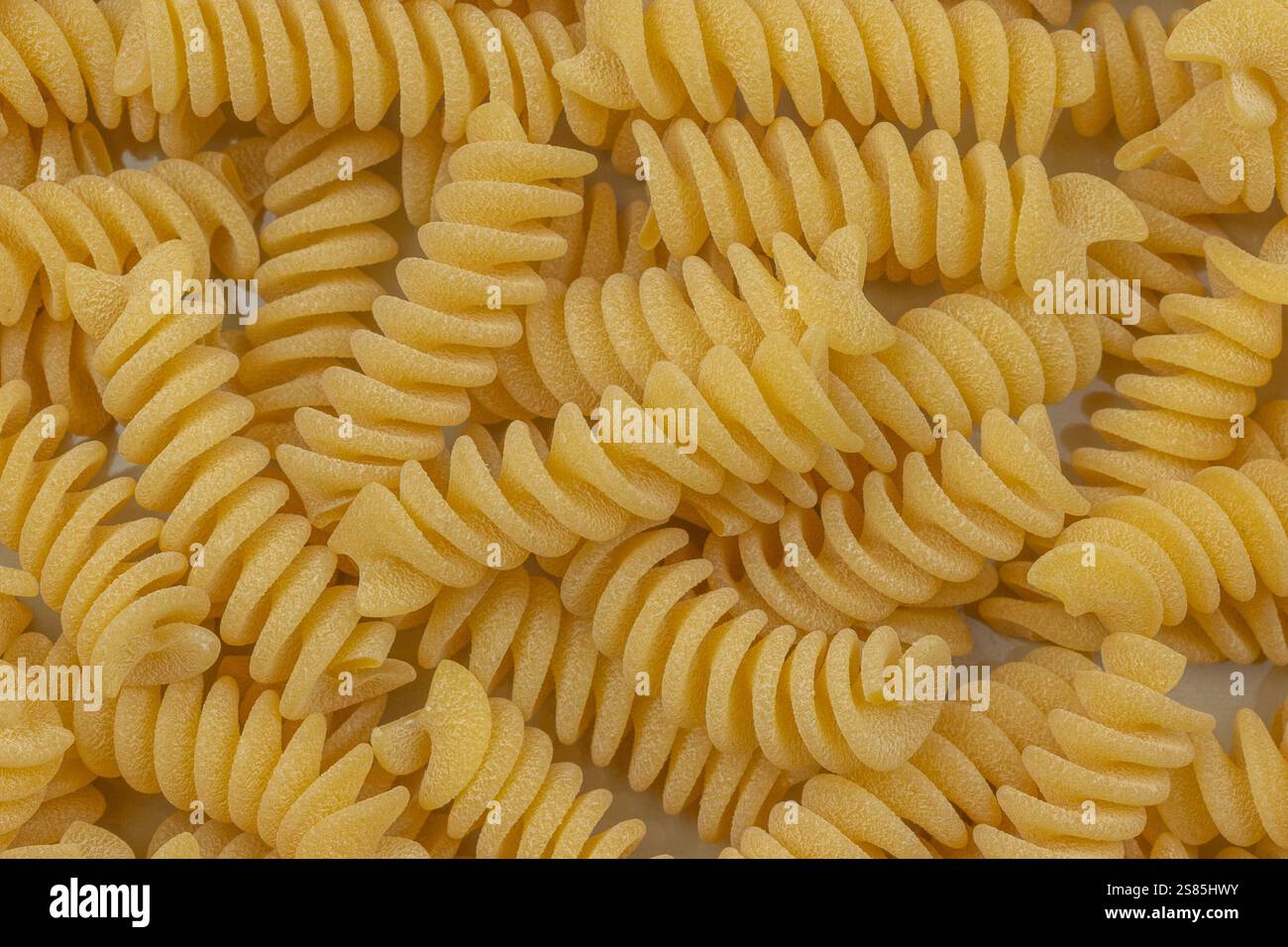 mucchio di fusilli crudi, primo piano, isolati su sfondo bianco Foto Stock