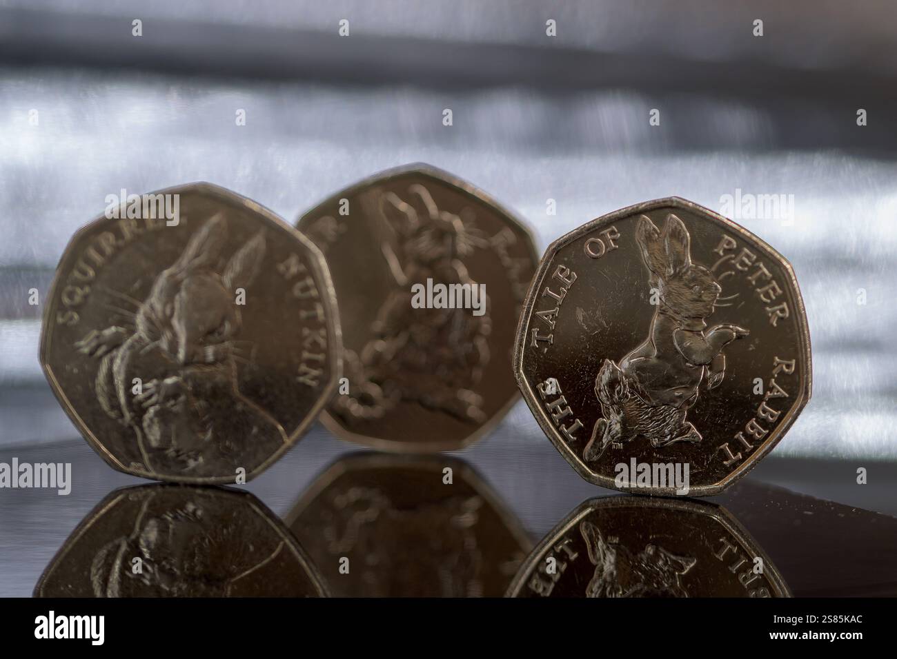 Sterling Coins, set Beatrix Potter da 50p, monete da 50 pence, posizionate su una superficie riflettente Foto Stock